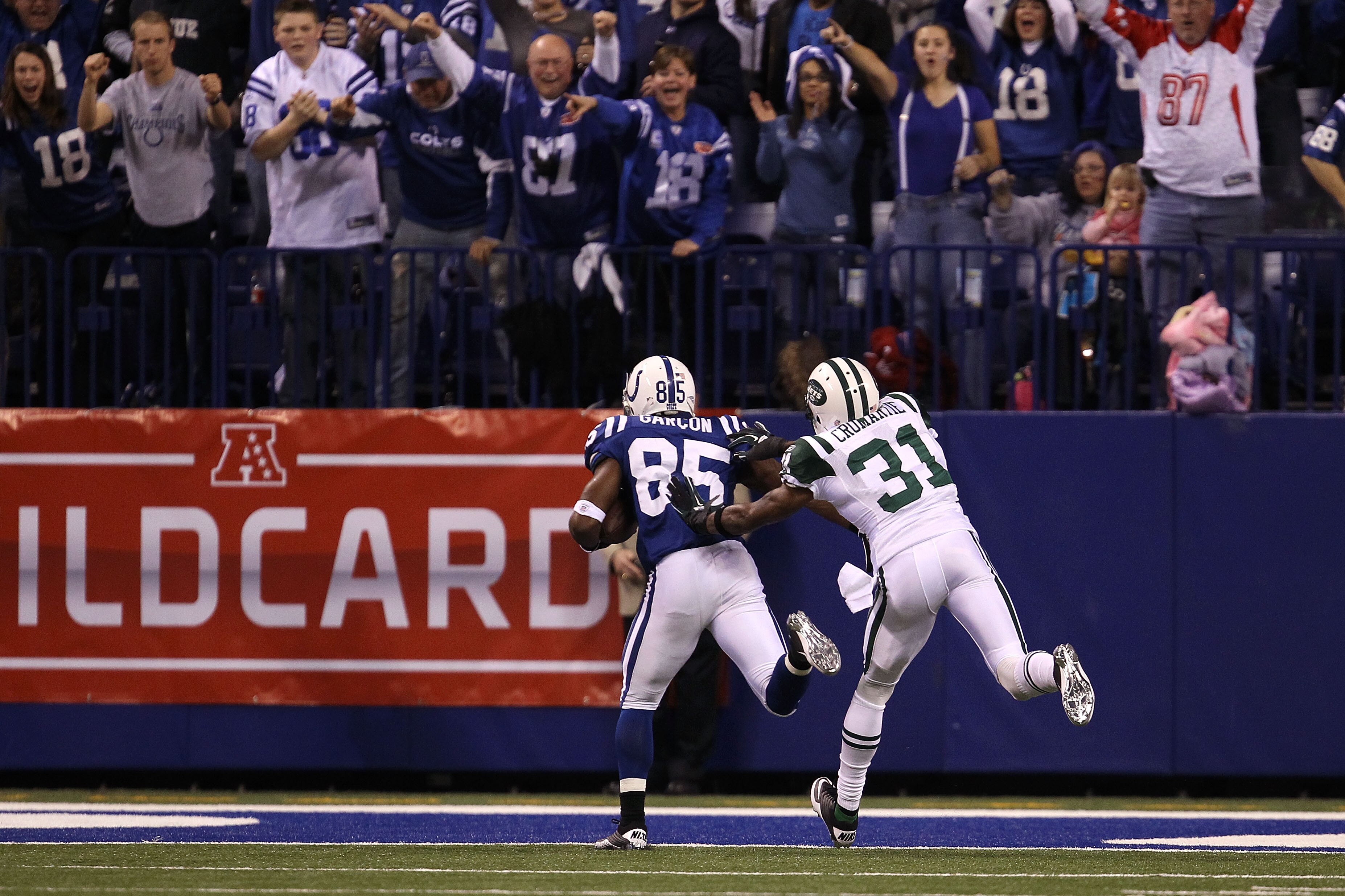 INDIANAPOLIS, IN - JANUARY 08:  Pierre Garcon #85 of the Indianapolis Colts scores on a 57-yard touchdown reception in the seocnd quarter against Antonio Cromartie #31 of the New York Jets during their 2011 AFC wild card playoff game at Lucas Oil Stadium