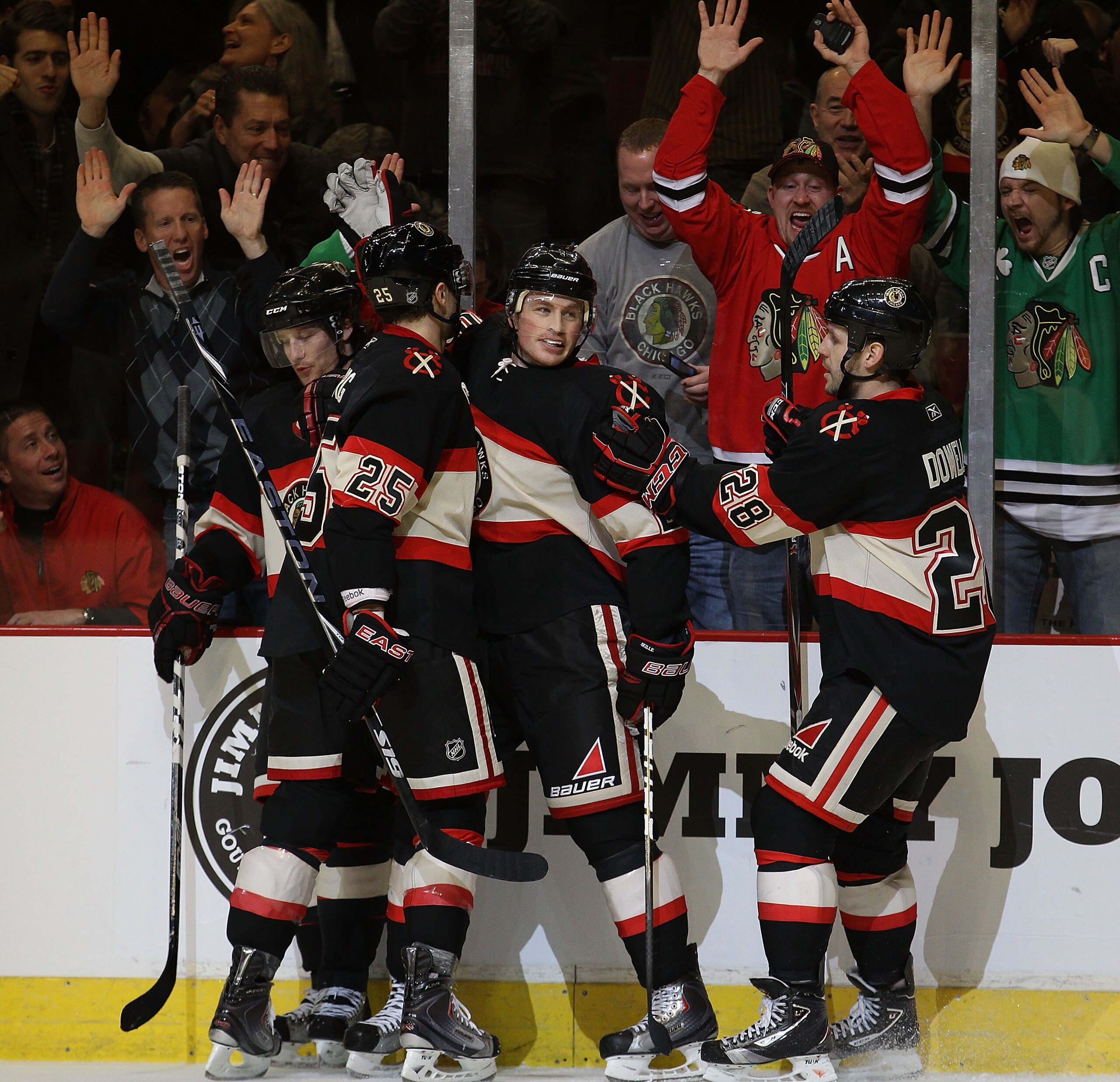 CHICAGO, IL - JANUARY 12: Jack Skille #20 of the Chicago Blackhawks (center) is congratulated by (L-R) Duncan Keith #2, Viktor Stalberg #25 and Jack Dowell #28 after scoring a goal in the 3rd period against the Colorado Avalanche at the United Center on J
