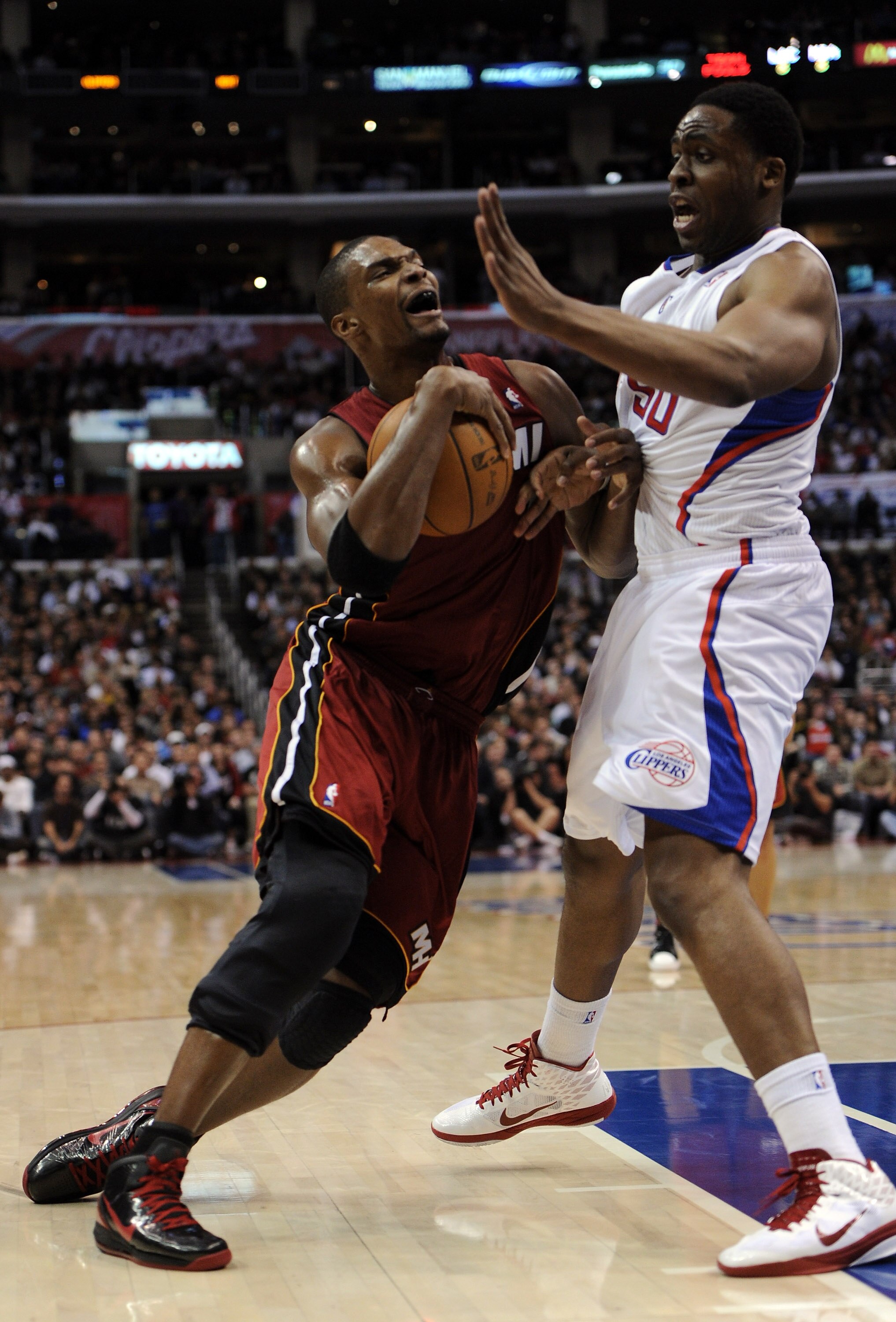 LOS ANGELES, CA - JANUARY 12:  Chris Bosh #1 of the Miami Heat goes to the hoop in front of Ike Diogu #50 of the Los Angeles Clippers during a 111-105 Clipper win at the Staples Center on January 12, 2011 in Los Angeles, California.  NOTE TO USER: User ex