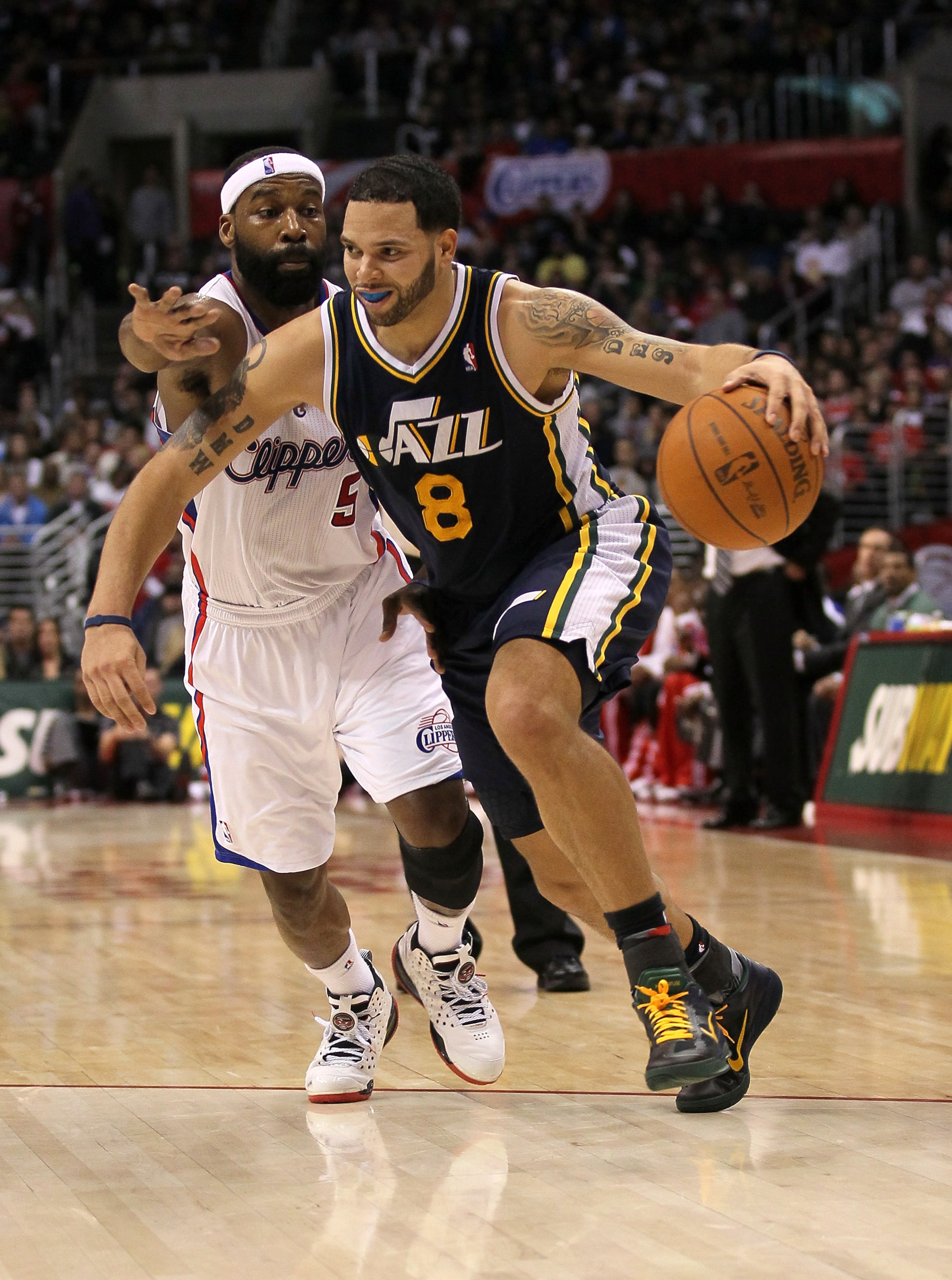 LOS ANGELES, CA - DECEMBER 29:  Deron Williams #8 of the Utah Jazz drives past Baron Davis #5 of the Los Angeles Clippers at Staples Center on December 29, 2010 in Los Angeles, California.   The Jazz won 103-85.  NOTE TO USER: User expressly acknowledges