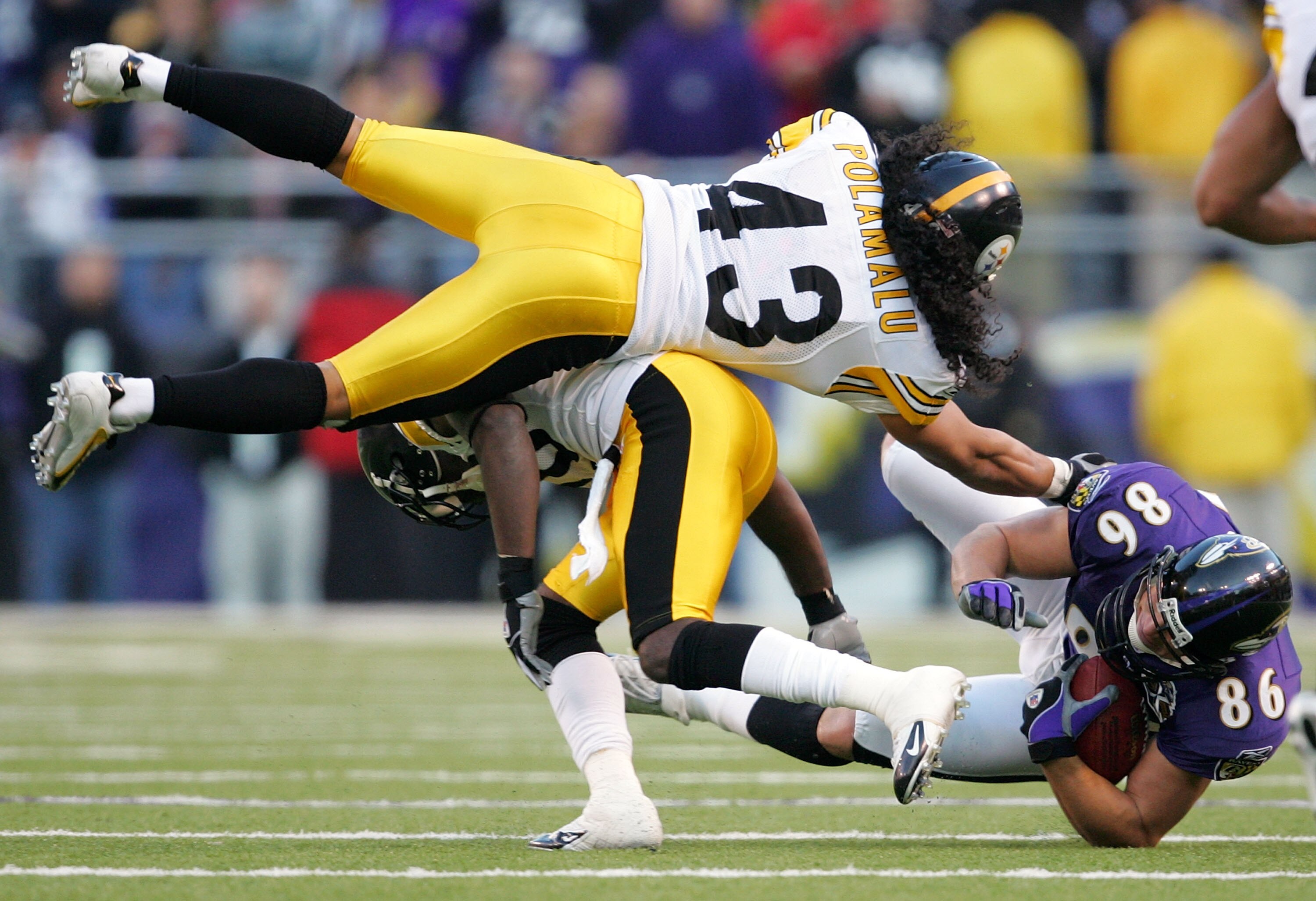 BALTIMORE - NOVEMBER 20:  Troy Polamalu #43 of the Pittsburgh Steelers leaps over the back of teammate Bryant McFadden #20 as he tries to tackle Todd Heap #86 of the Baltimore Ravens during the second half of the game on November 20, 2005 at M&T Bank Stad