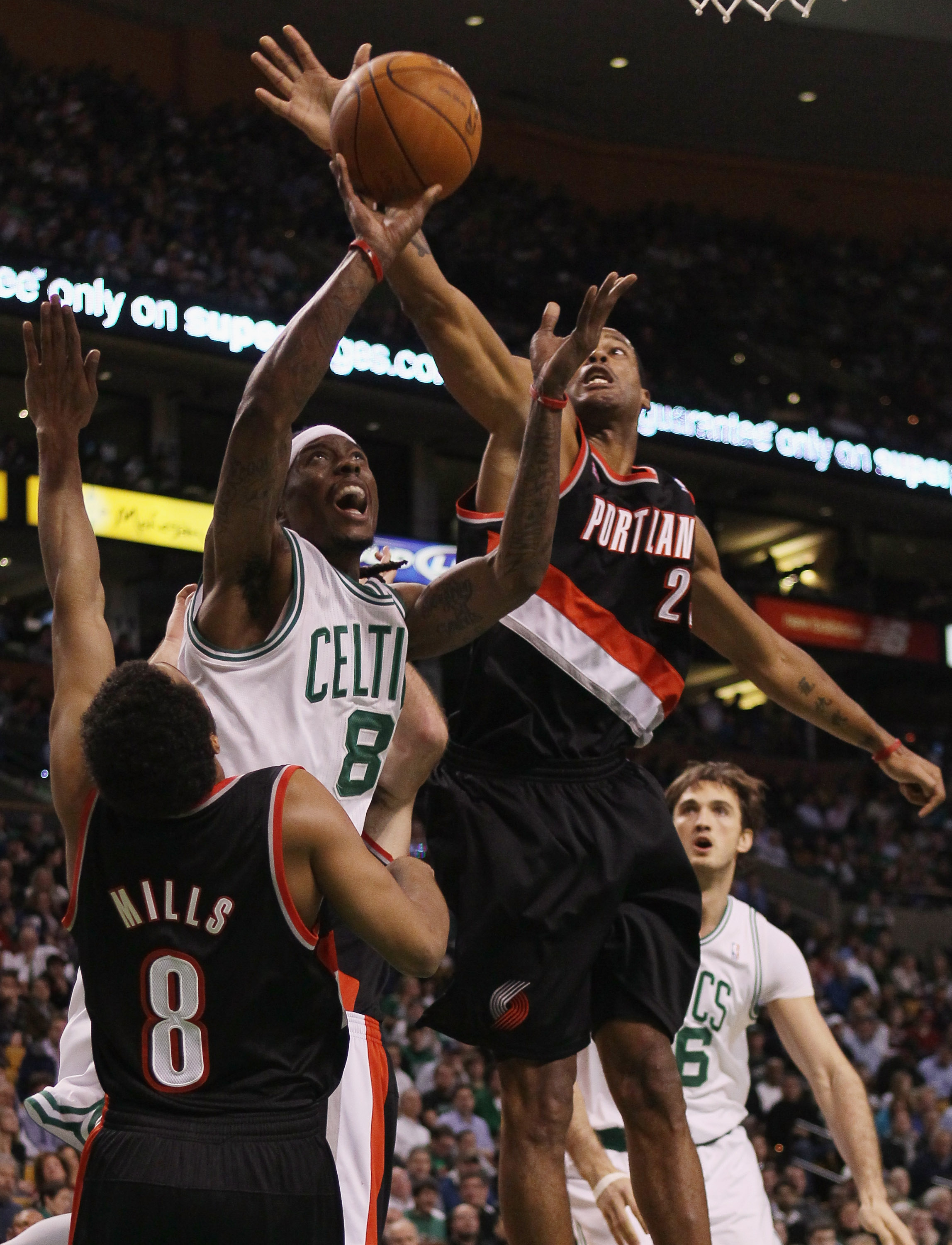 BOSTON - DECEMBER 01:  Marquis Daniels #8 of the Boston Celtics tries to take a shot as Marcus Camby #23 and Patrick Mills #8 of the Portland Trailblazers defend on December 1, 2010 at the TD Garden in Boston, Massachusetts.  NOTE TO USER: User expressly