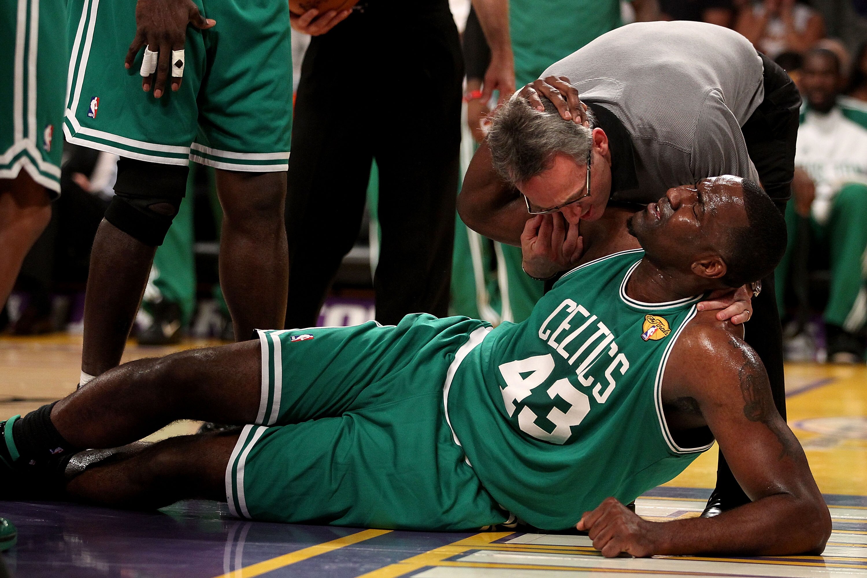 LOS ANGELES, CA - JUNE 15:  Kendrick Perkins #43 of the Boston Celtics is attended to by the trainer in the first half against the Los Angeles Lakers in Game Six of the 2010 NBA Finals at Staples Center on June 15, 2010 in Los Angeles, California.  NOTE T