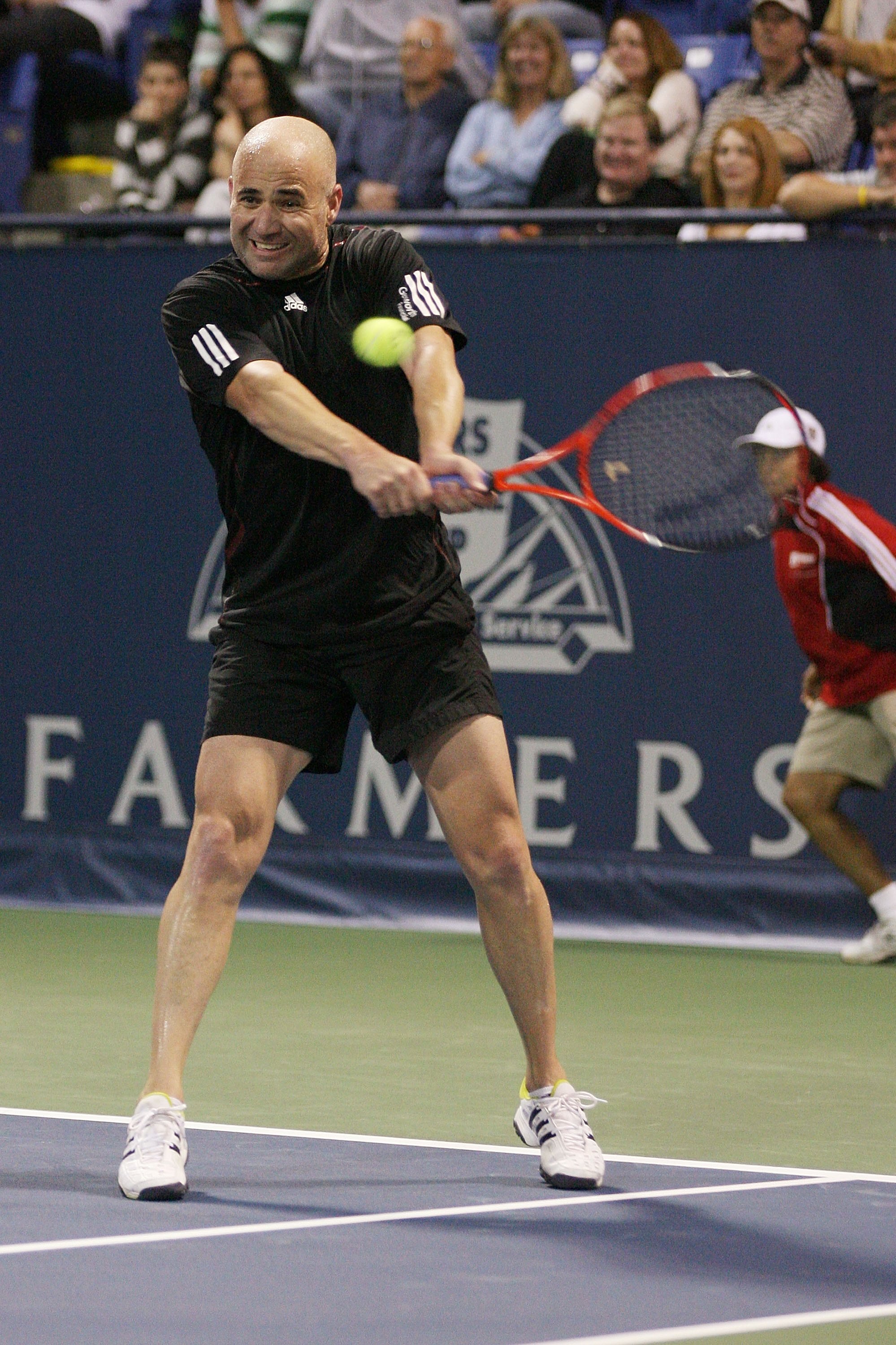 LOS ANGELES, CA - JULY 24:  Andre Agassi hits a backhand shot against John McEnroe during the Stars Under the Stars gala on July 24, 2010 at the Los Angeles Tennis Center in Los Angeles, California.  Andre Agassi defeated John McEnroe 6-4, 6-2.  (Photo by