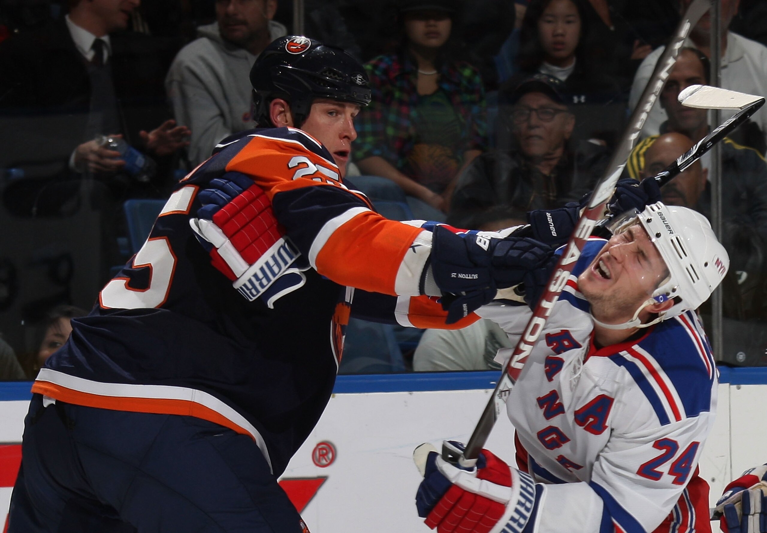 UNIONDALE, NY - DECEMBER 17: Brandon Dubinsky #24 of the New York Rangers is hit by Andy Sutton #25 of the New York Islanders at the Nassau Coliseum on December 17, 2009 in Uniondale, New York. The Rangers defeated the Islanders 5-2. (Photo by Bruce Benne