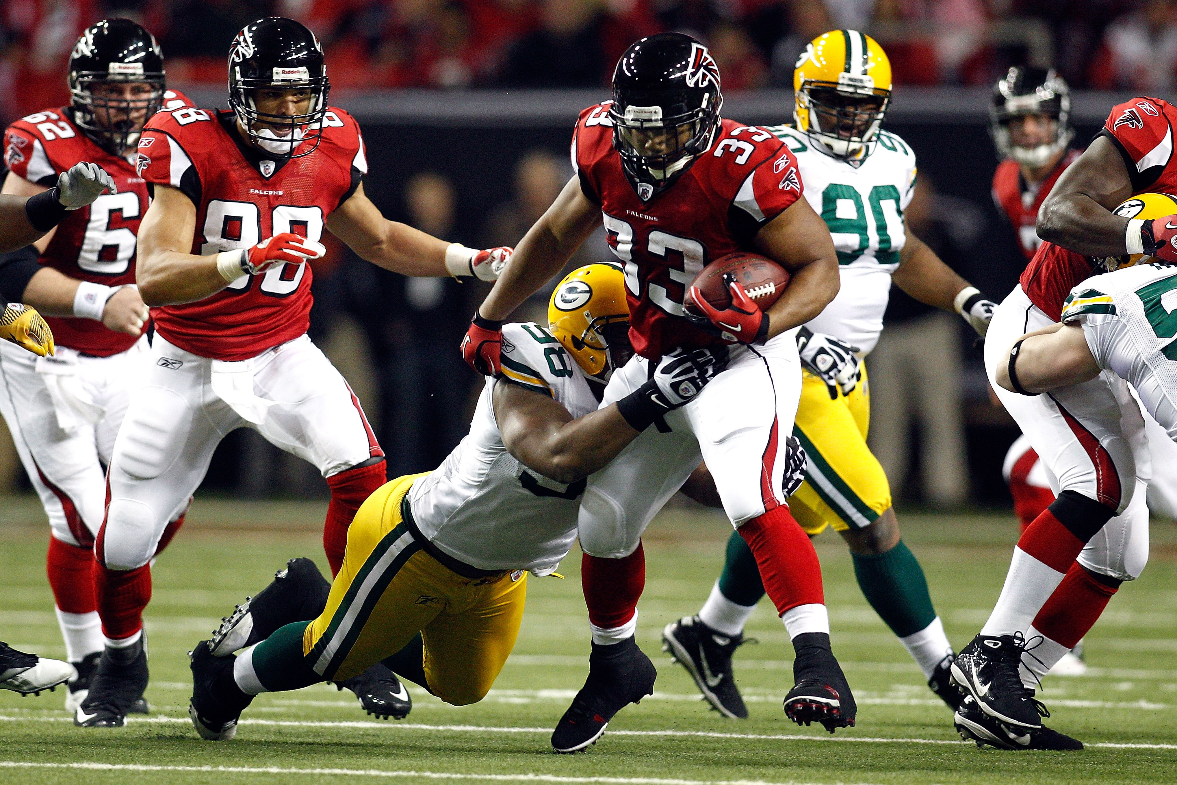 ATLANTA, GA - JANUARY 15:  Michael Turner #33 of the Atlanta Falcons runs the ball in the first quarter against C.J. Wilson #98 of the Green Bay Packers during their 2011 NFC divisional playoff game at Georgia Dome on January 15, 2011 in Atlanta, Georgia.