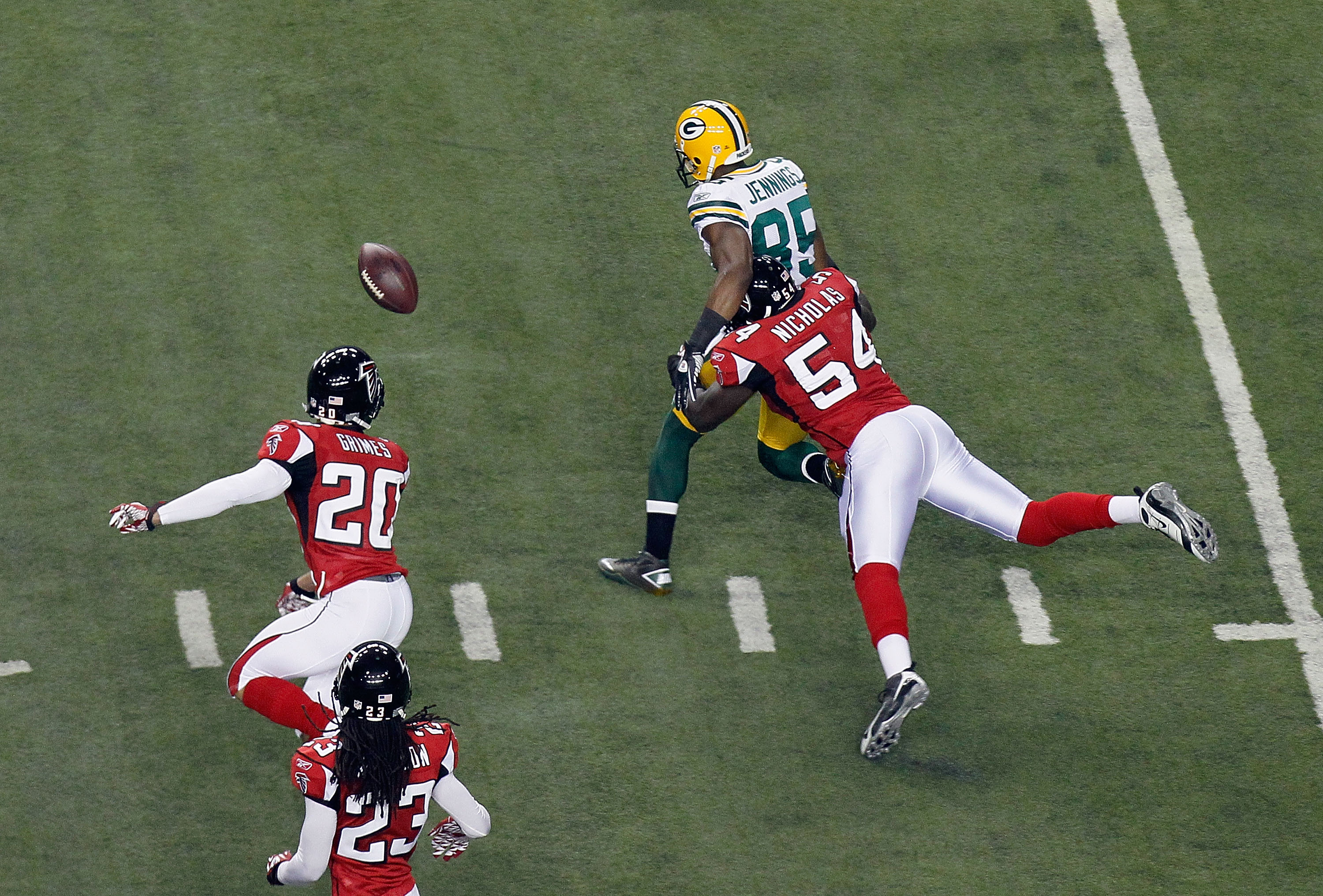 ATLANTA, GA - JANUARY 15:  Greg Jennings #85 of Green Bay Packers fumbles the ball in the first quarter against Stephen Nicholas #54 and Brent Grimes #20 of the Atlanta Falcons during their 2011 NFC divisional playoff game at Georgia Dome on January 15, 2