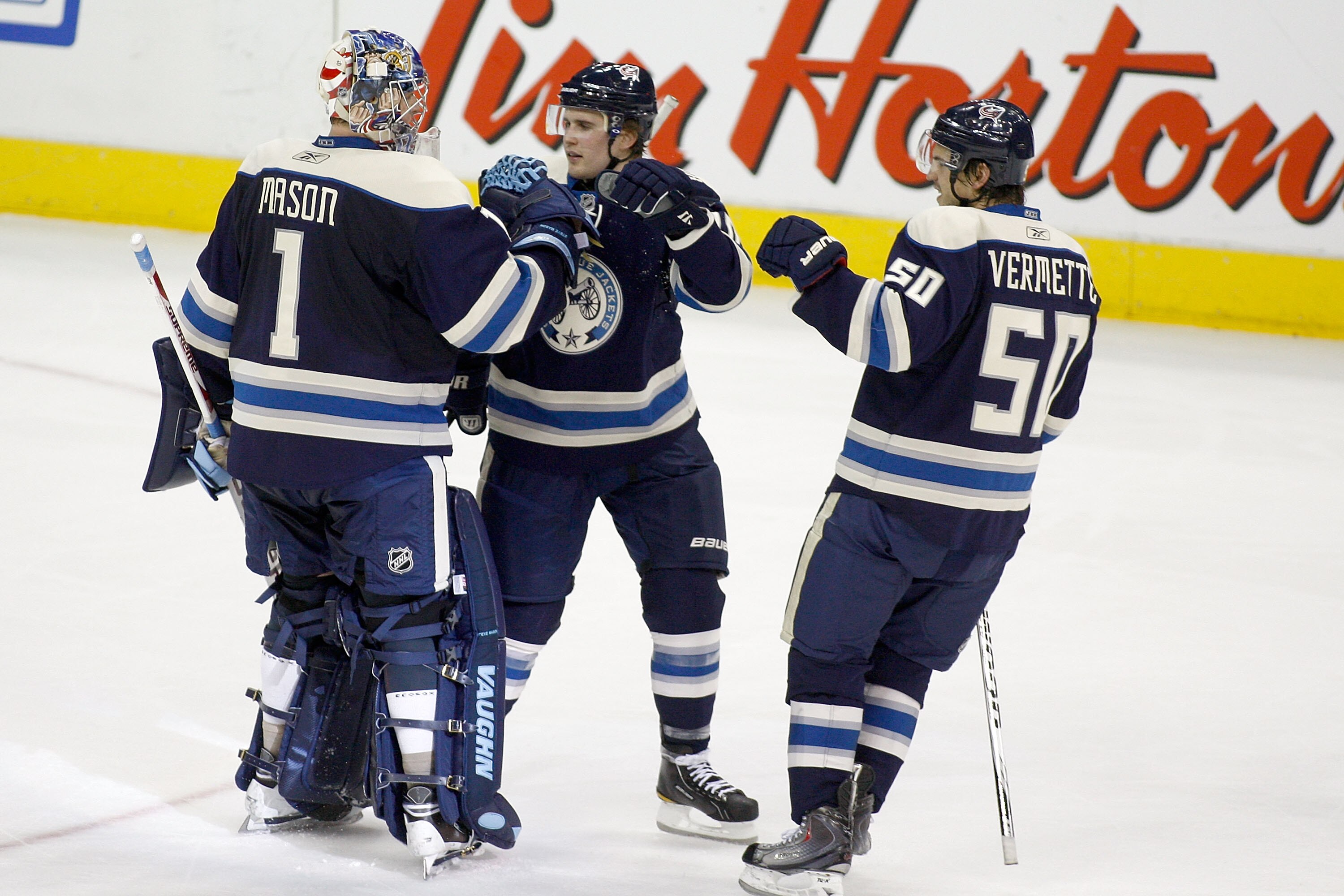 COLUMBUS, OH - JANUARY 14:  Steve Mason #1of the Columbus Blue Jackets is congratulated by teammates Kris Russell #10 and Antoine Vermette #50 after defeating the Detroit Red Wings 3-2 in a shootout on January 14, 2011 at Nationwide Arena in Columbus, Ohi