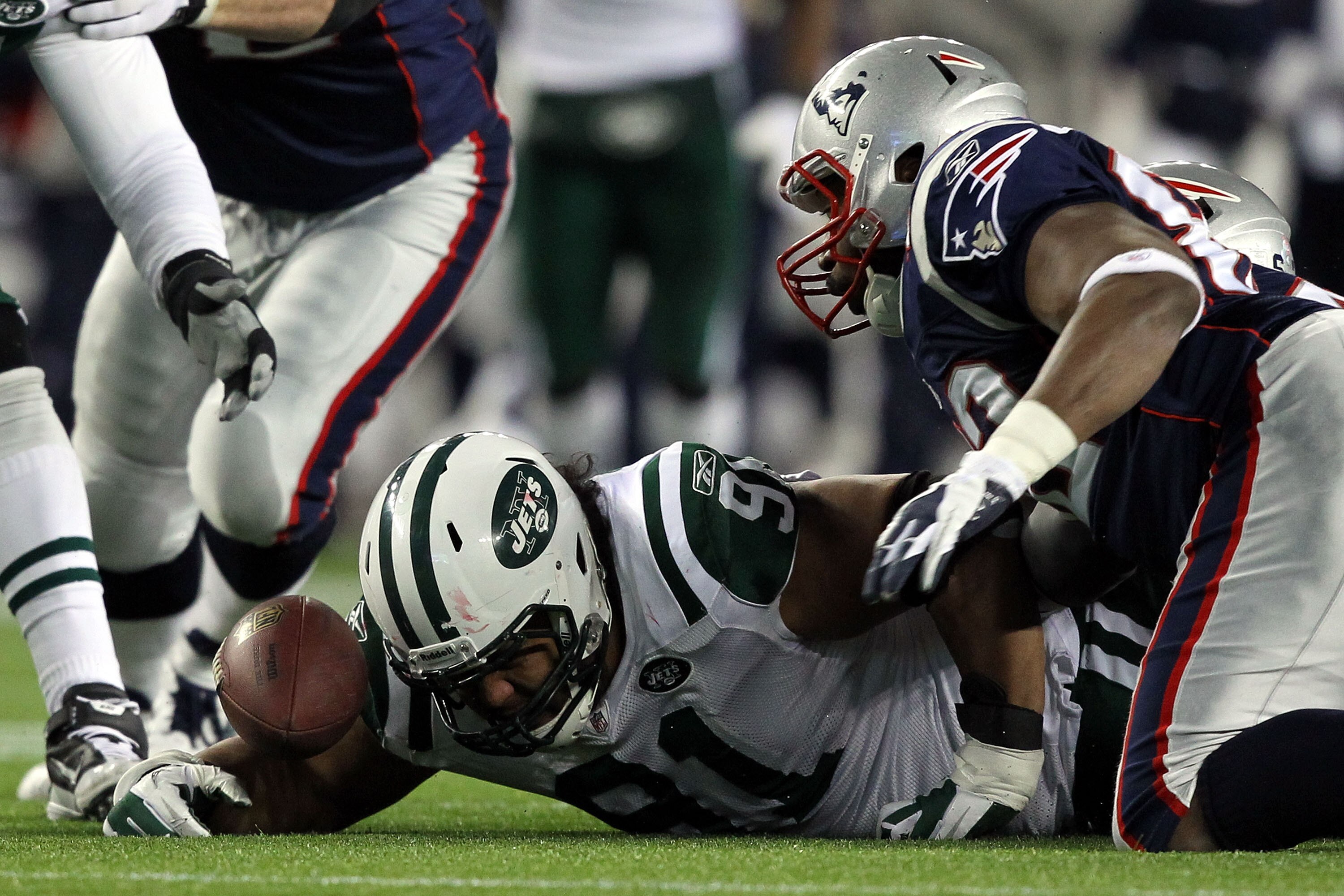 FOXBORO, MA - JANUARY 16: Sione Pouha #91 of the New York Jets and Alge Crumpler #82 of the New England Patriots fight to recover a fumble by Tom Brady #12 of the New England Patriots of the New York Jets against during their 2011 AFC divisional playoff g