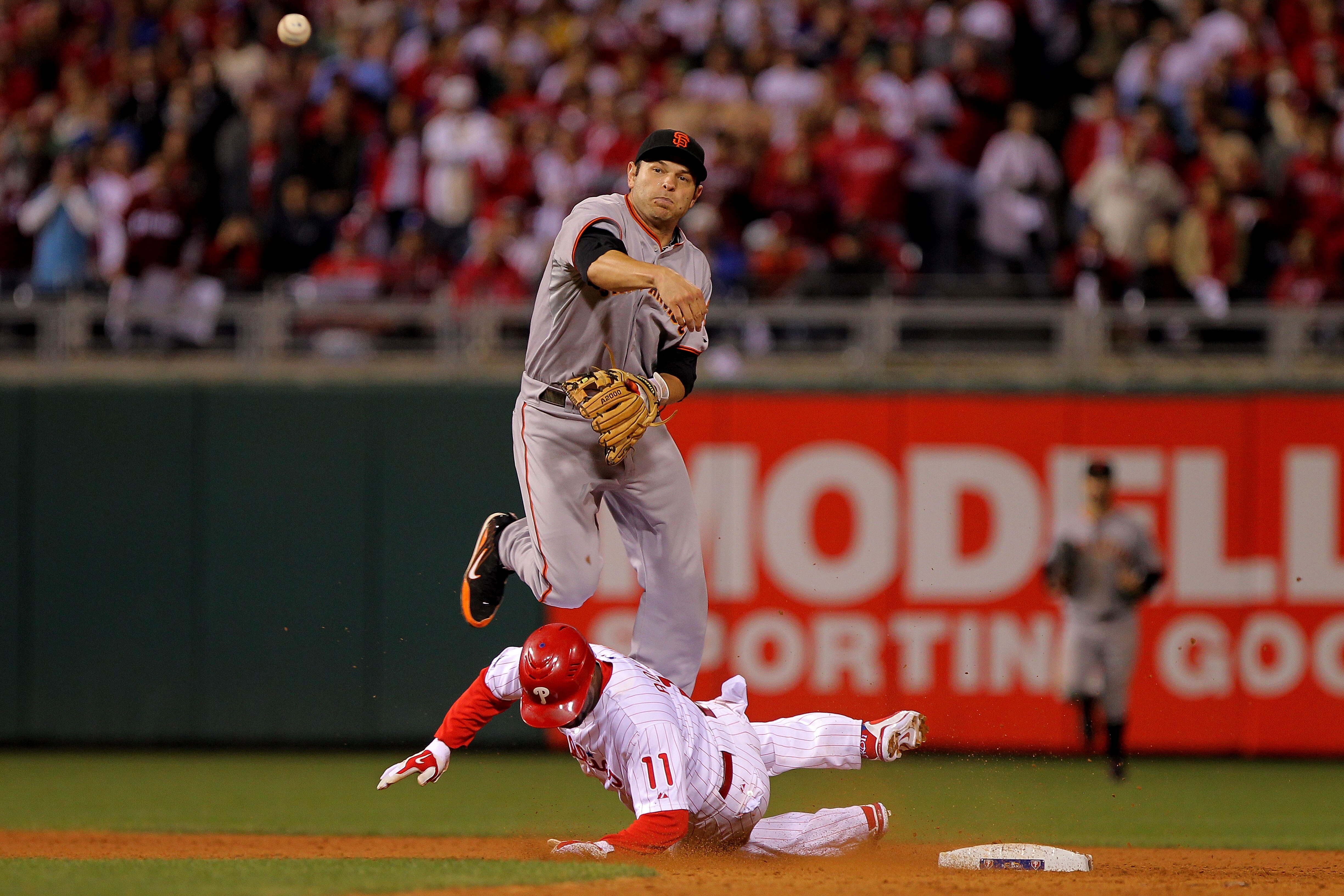 PHILADELPHIA - OCTOBER 23:  Jimmy Rollins #11 of the Philadelphia Phillies breaks up a double play under Freddy Sanchez #21 of the San Francisco Giants in the ninth inning of Game Six of the NLCS during the 2010 MLB Playoffs at Citizens Bank Park on Octob