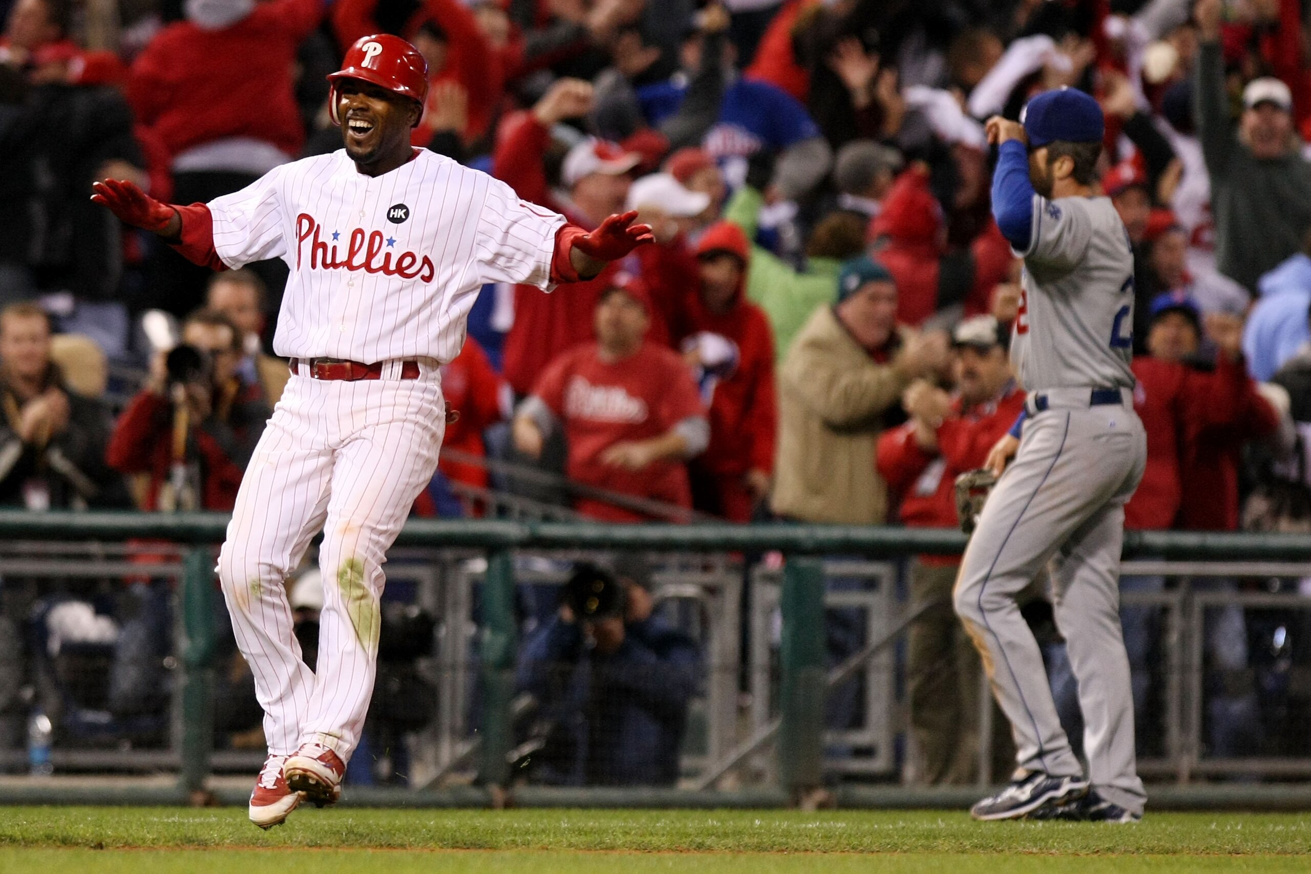 PHILADELPHIA - OCTOBER 19:  Jimmy Rollins #11 of the Philadelphia Phillies celebrates after he hit a game-winning walkoff 2-run double to beat the Los Angeles Dodgers 5-4 as Casey Blake #23 of the Dodgers walks off the field dejected in Game Four of the N