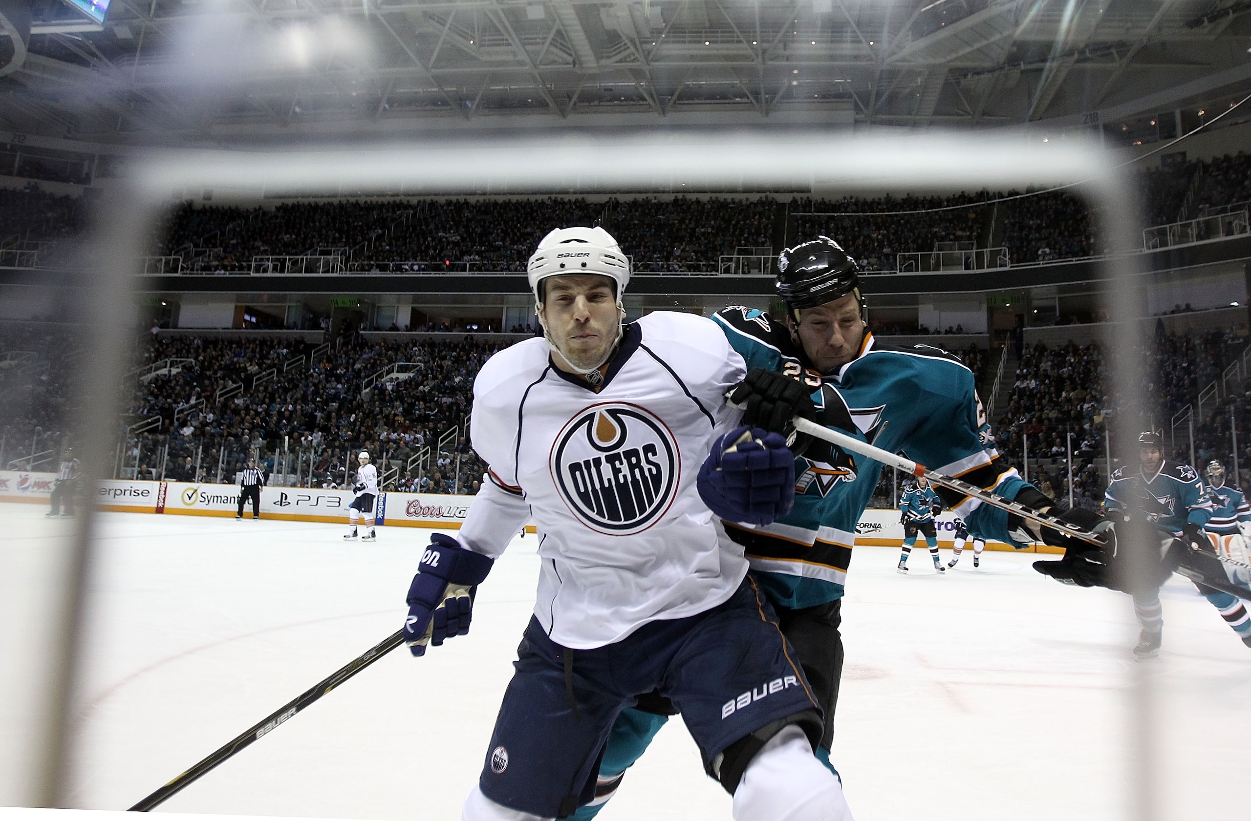 SAN JOSE, CA - DECEMBER 21:  Jean-Francois Jacques #22 of the Edmonton Oilers is hit by Ryane Clowe #29 of the San Jose Sharks at HP Pavilion on December 21, 2010 in San Jose, California.  (Photo by Ezra Shaw/Getty Images)