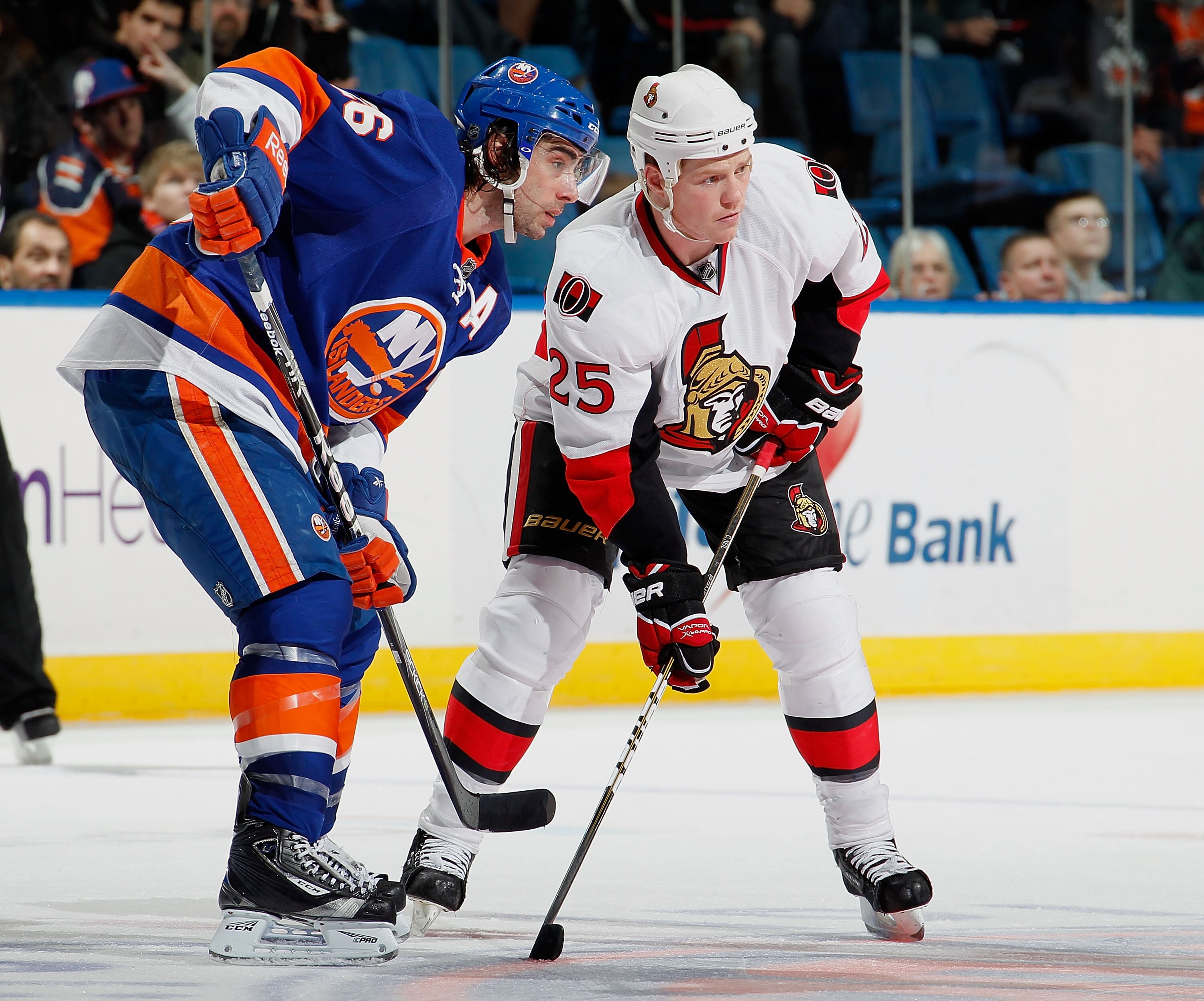 UNIONDALE, NY - JANUARY 13:  Chris Neil #25 of the Ottawa Senators and Matt Moulson #26 of the New York Islanders wait to faceoff during an NHL hockey game at the Nassau Coliseum on January 13, 2011 in Uniondale, New York.  (Photo by Paul Bereswill/Getty