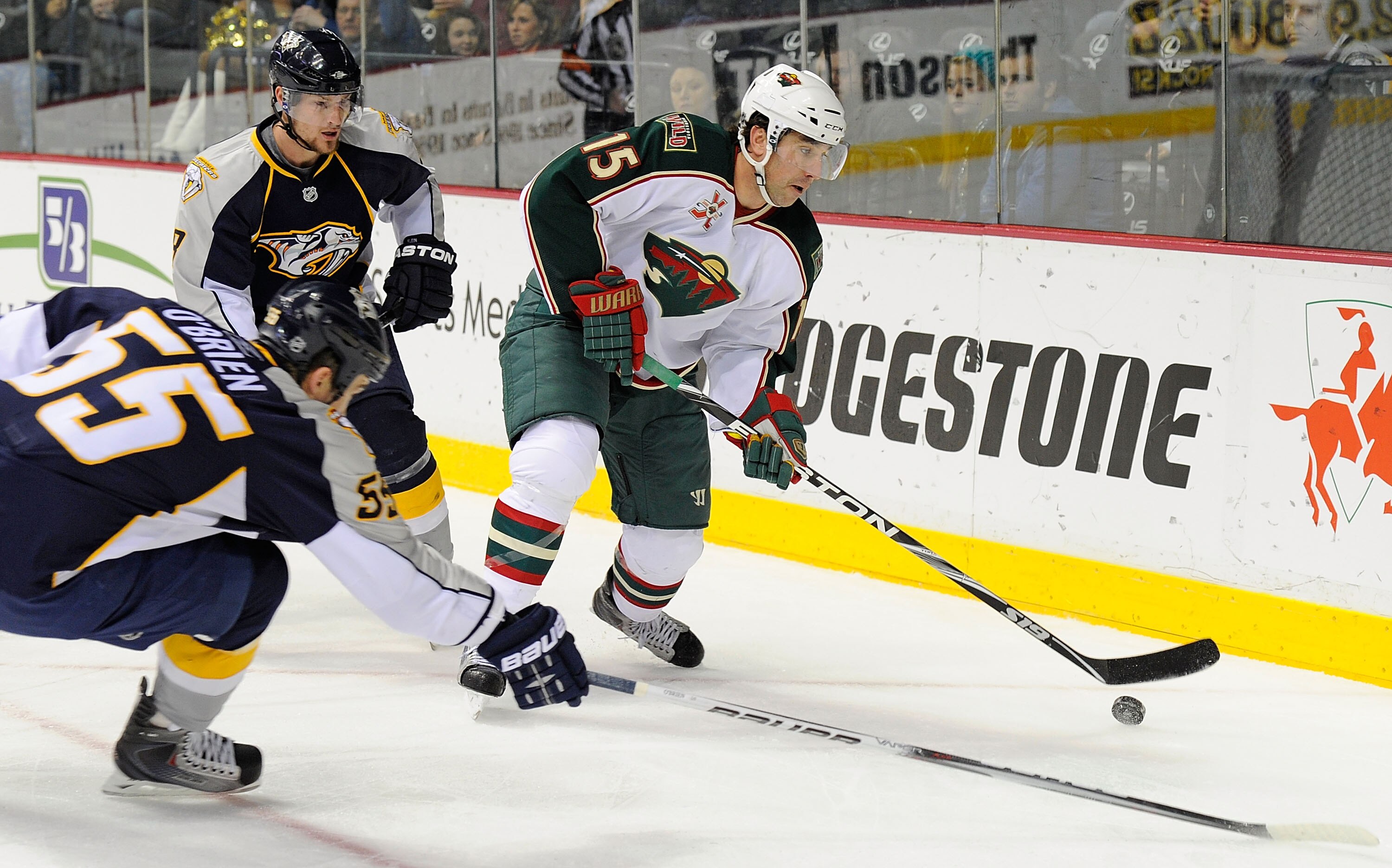 NASHVILLE, TN - JANUARY 11:   Andrew Brunette #15 of the Minnesota Wild skates through the defense of Kevin Klein #8 and Shane O'Brien #55 of the Nashville Predators on January 11, 2011 at the Bridgestone Arena in Nashville, Tennessee.  (Photo by Frederic