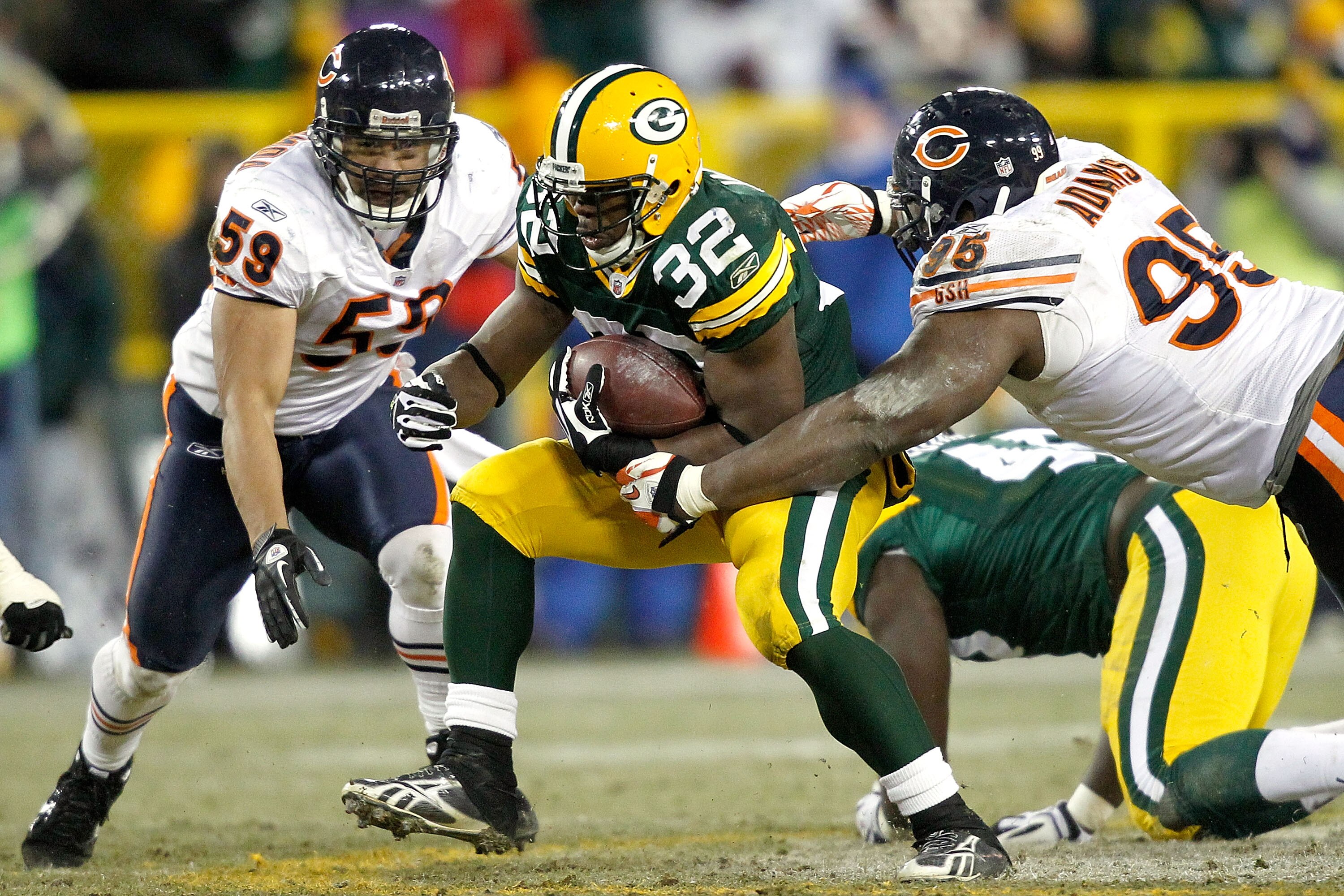 GREEN BAY, WI - JANUARY 02:  Kahlil Bell #32 of the Green Bay Packers carries the ball against Pisa Tinoisamoa #59 and Anthony Adams #95 of the Chicago Bears at Lambeau Field on January 2, 2011 in Green Bay, Wisconsin.  (Photo by Matthew Stockman/Getty Im