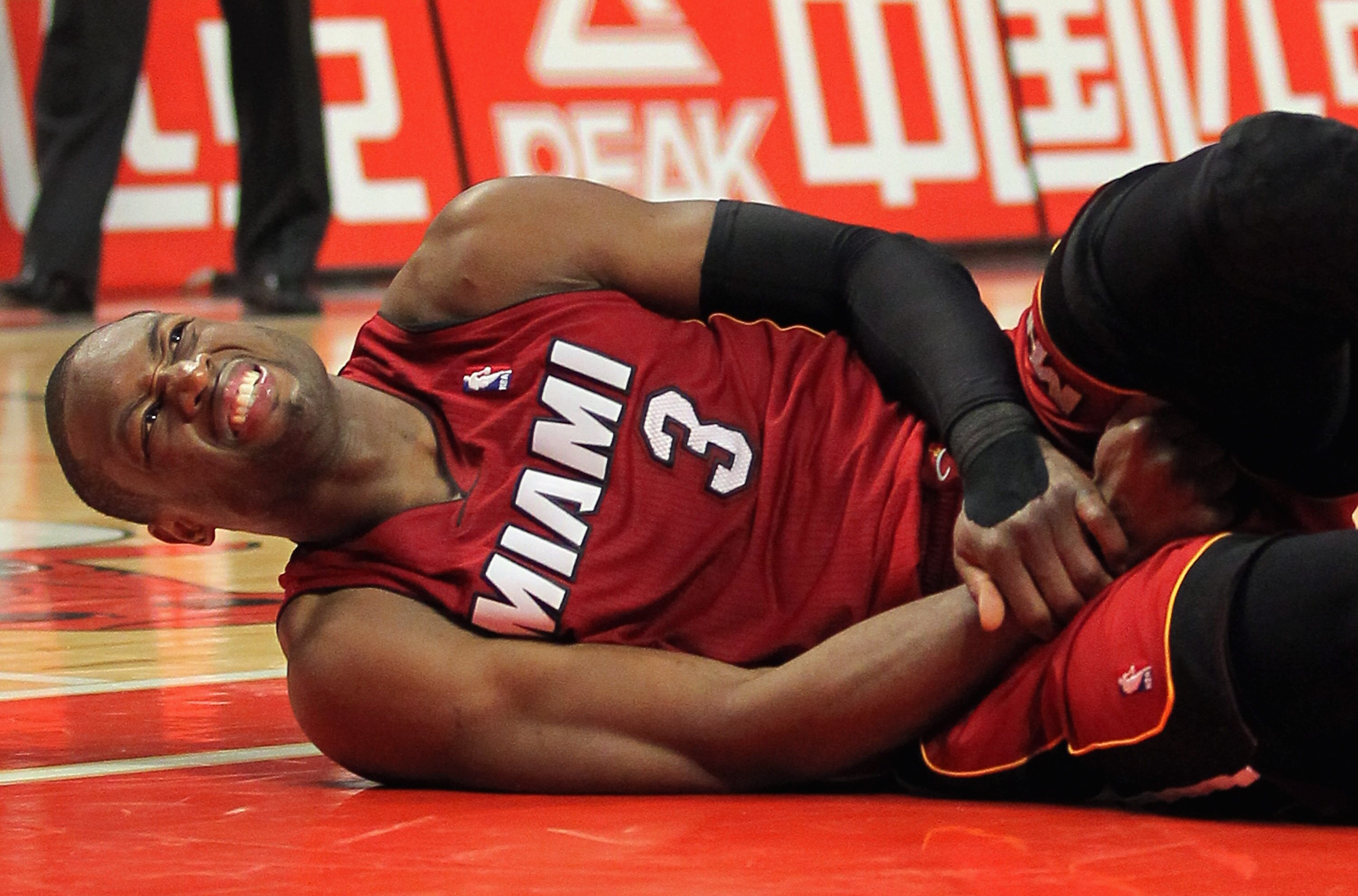 CHICAGO, IL - JANUARY 15:  Dwayne Wade #3 of the Miami Heat grimaces as he lies on the floor after being fouled by the Chicago Bulls at the United Center on January 15, 2011 in Chicago, Illinois. NOTE TO USER: User expressly acknowledges and agrees that, 