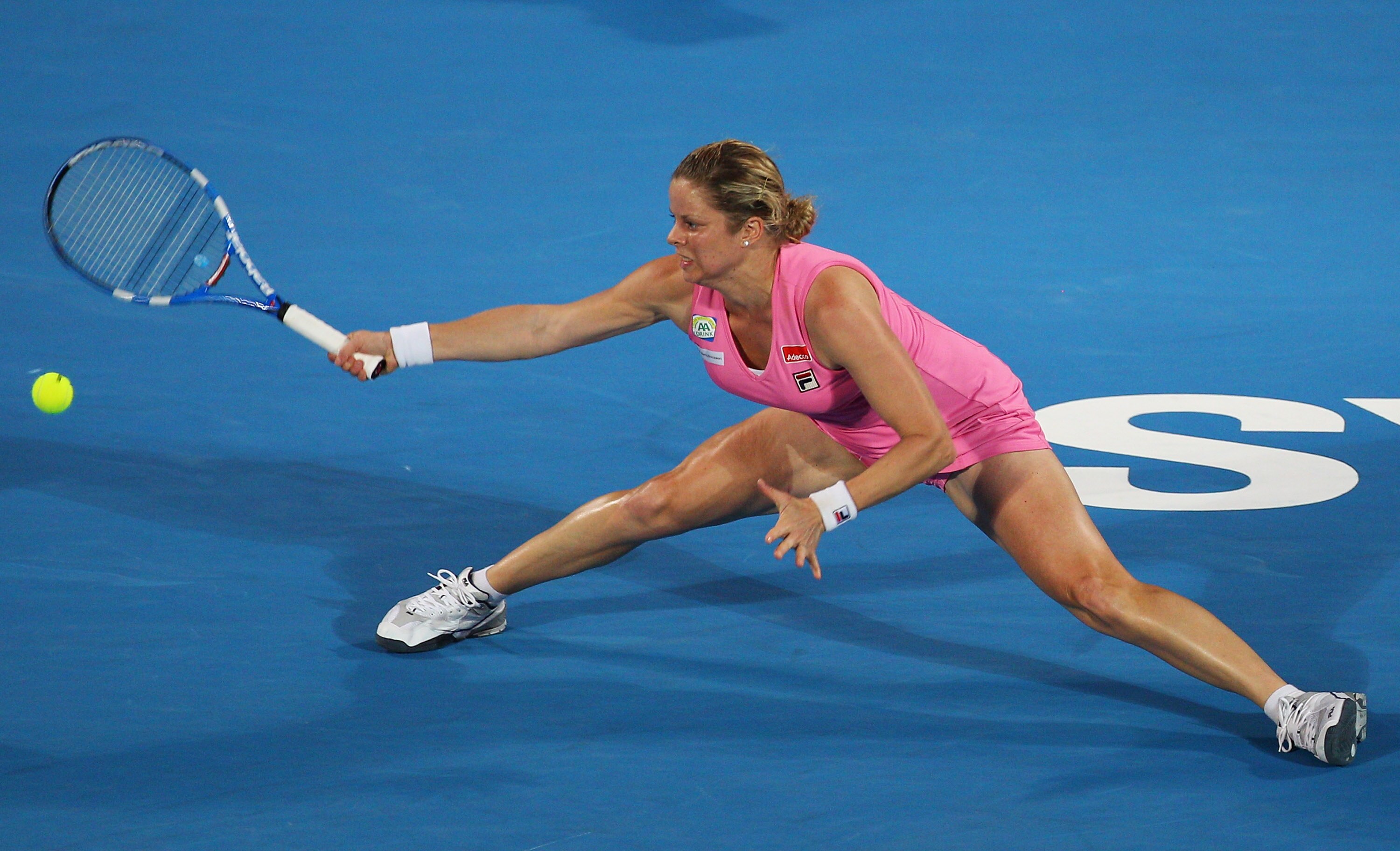 SYDNEY, AUSTRALIA - JANUARY 14:  Kim Clijsters of Belgium stretches to play a forehand in the women's final against Na Li of China during day six of the 2011 Medibank International at Sydney Olympic Park Tennis Centre on January 14, 2011 in Sydney, Austra