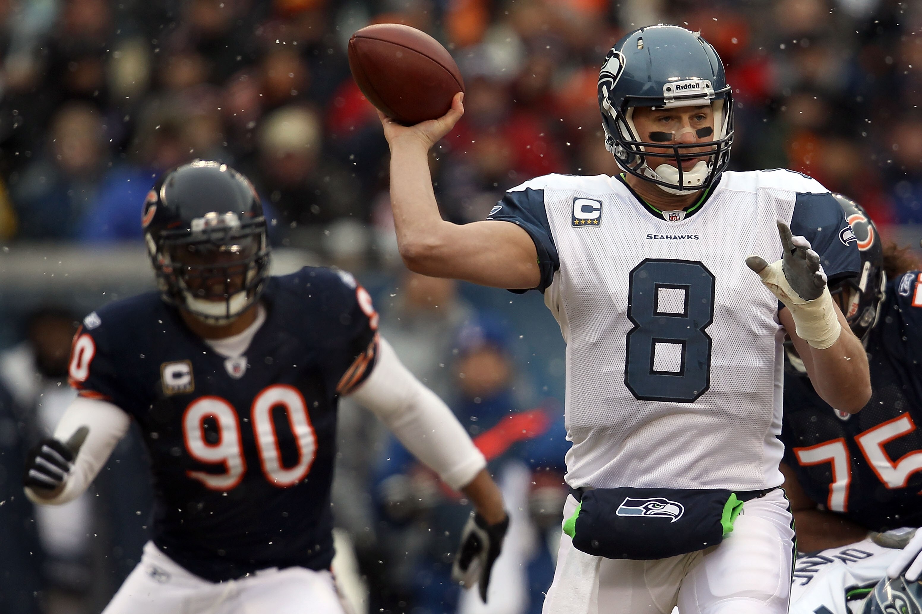 CHICAGO, IL - JANUARY 16:  Quarterback Matt Hasselbeck #8 of the Seattle Seahawks throws the ball as Julius Peppers #90 of the Chicago Bears attempts to run in for the sack in the first half in the 2011 NFC divisional playoff game at Soldier Field on Janu