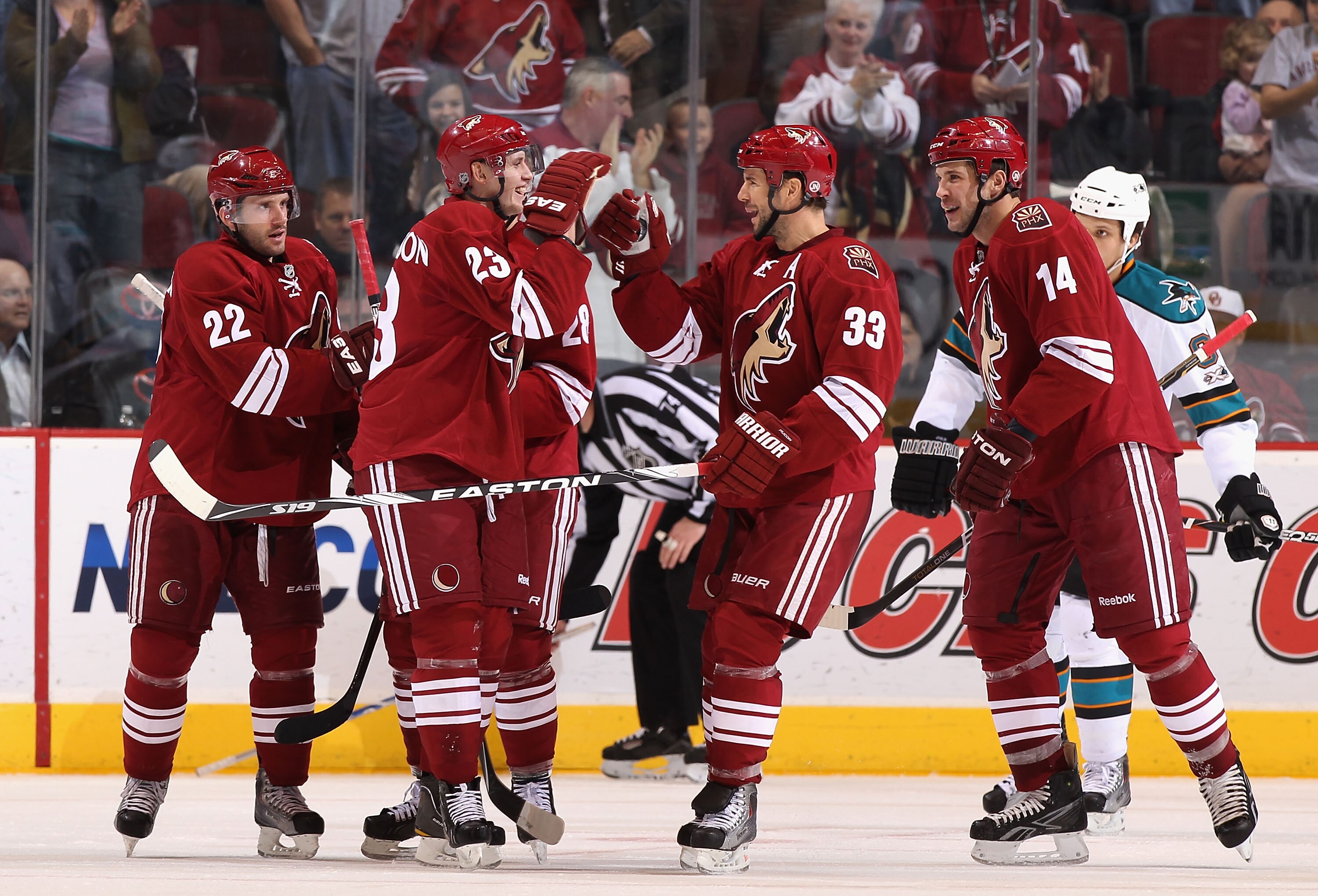 GLENDALE, AZ - JANUARY 17:  Oliver Ekman-Larsson #23 of the Phoenix Coyotes celebrates with teammate Adrian Aucoin #33 and Taylor Pyatt #14 after Ekman-Larsson scored his first career goal against the San Jose Sharks during the third period of the NHL gam