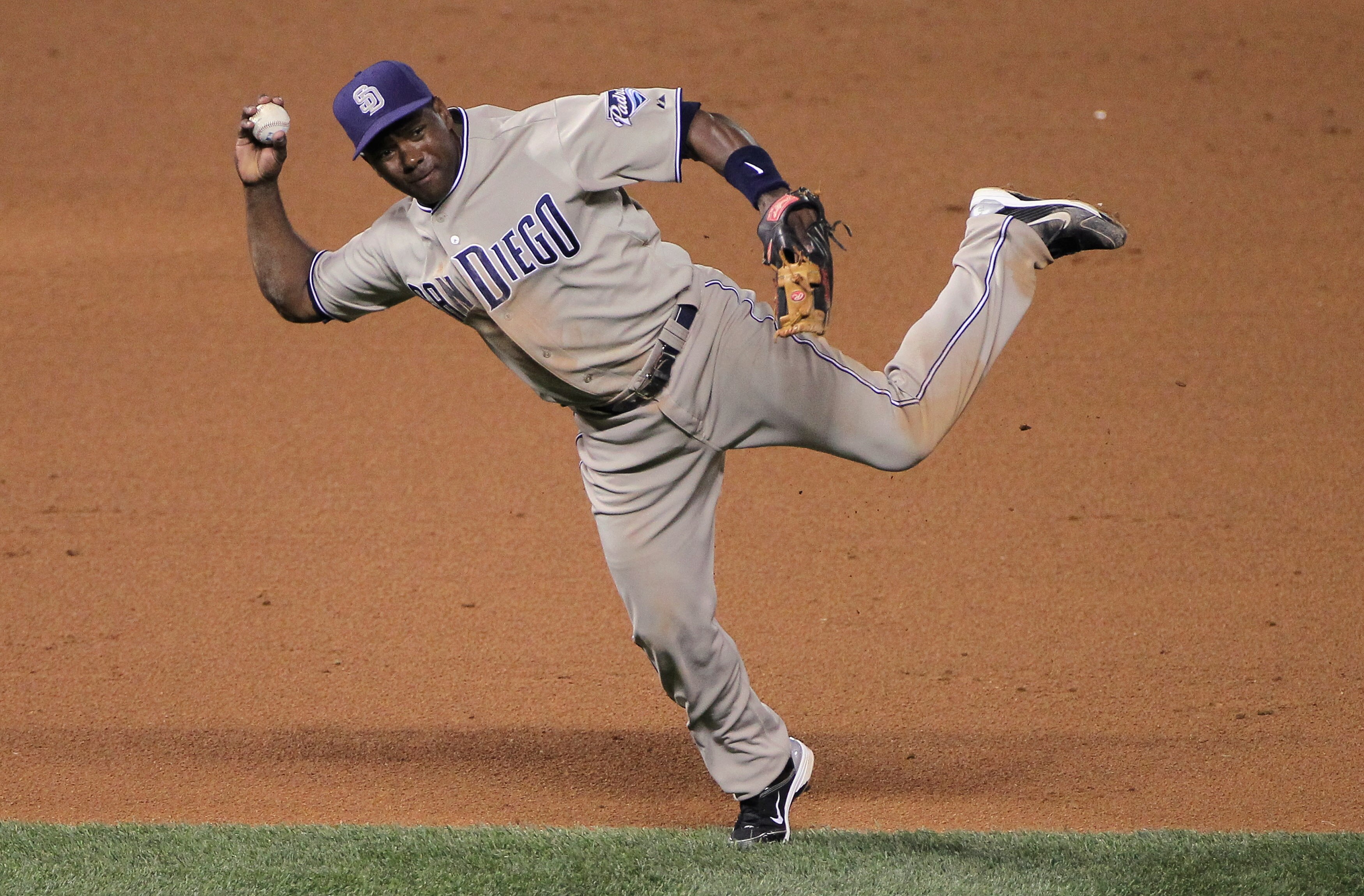 DENVER - SEPTEMBER 14:  Shortstop Miguel Tejada #10 of the San Diego Padres makes a bare handed stop and a late throw as Troy Tulowitzki of the Colorado Rockies is safe with a single on a soft grounder in the fourth inning at Coors Field on September 14,
