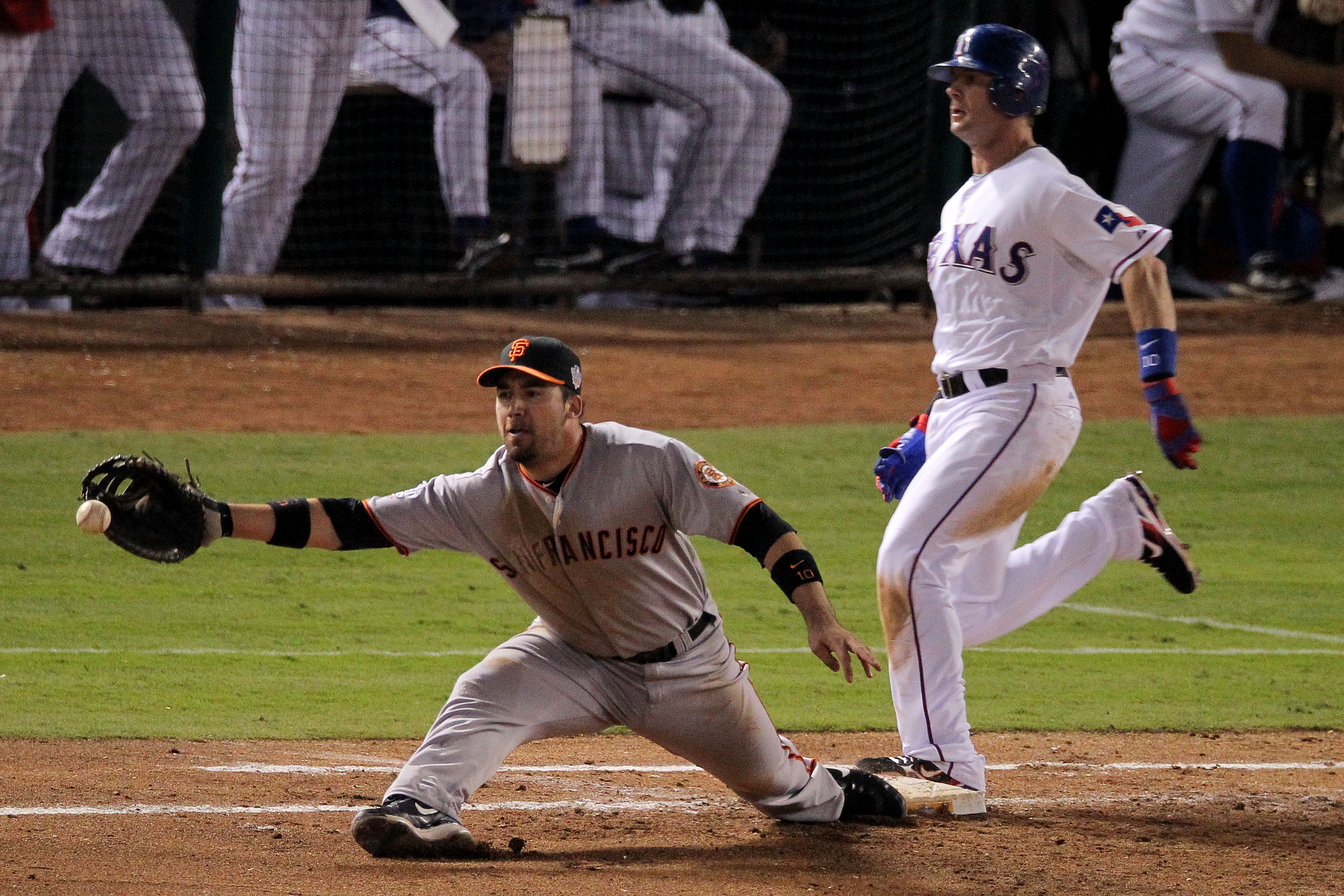 ARLINGTON, TX - OCTOBER 31:  Michael Young #10 of the Texas Rangers is safe at first base as Travis Ishikawa #10 of the San Francisco Giants reaches for a throw from teammate Freddy Sanchez #21 (not pictured) in the fourth inning in Game Four of the 2010