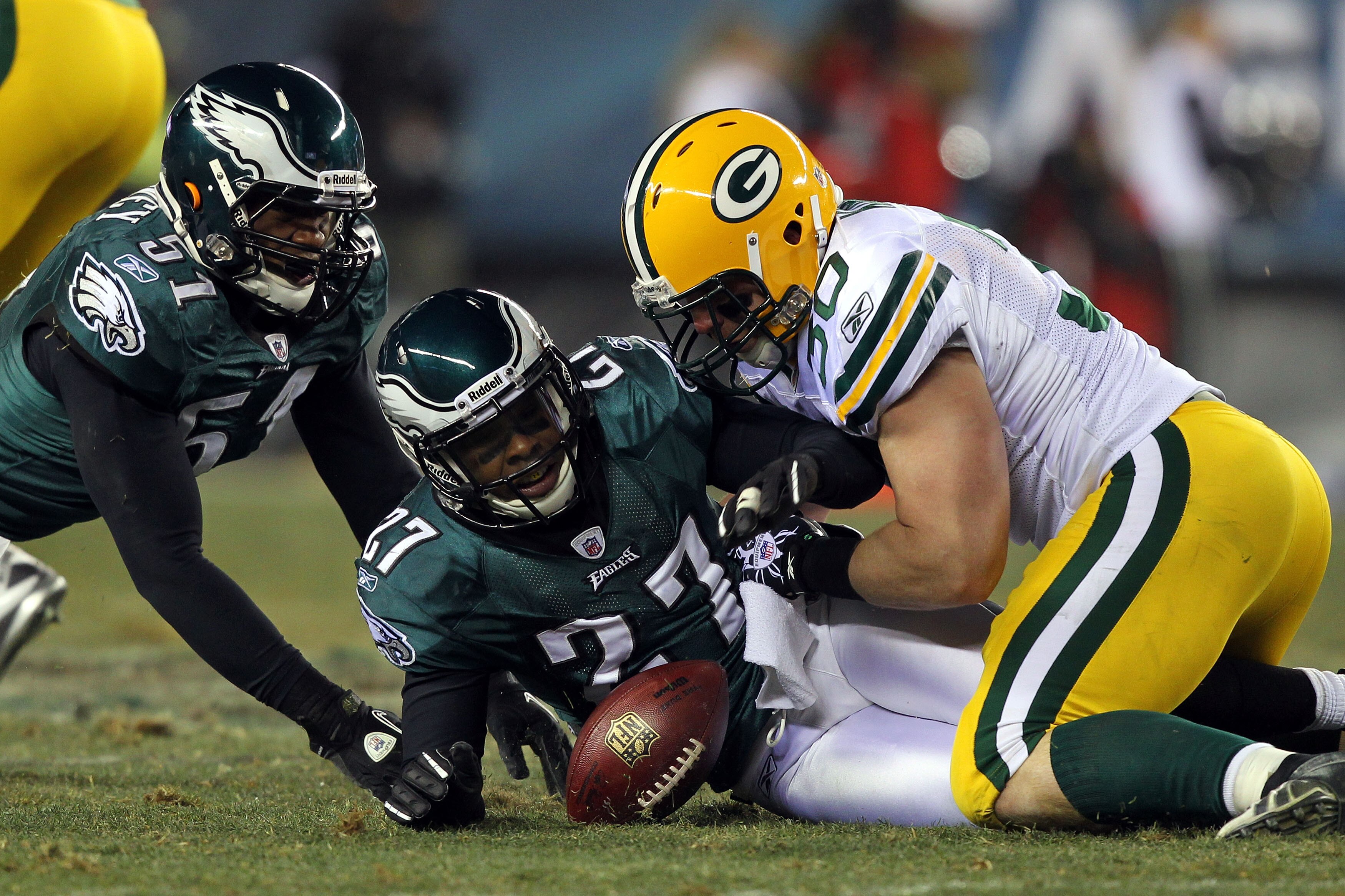 PHILADELPHIA, PA - JANUARY 09:  John Kuhn #30 of the Green Bay Packers fights for a fumble against Quintin Mikell #27 and Jamar Chaney #51 of the Philadelphia Eagles during the 2011 NFC wild card playoff game at Lincoln Financial Field on January 9, 2011