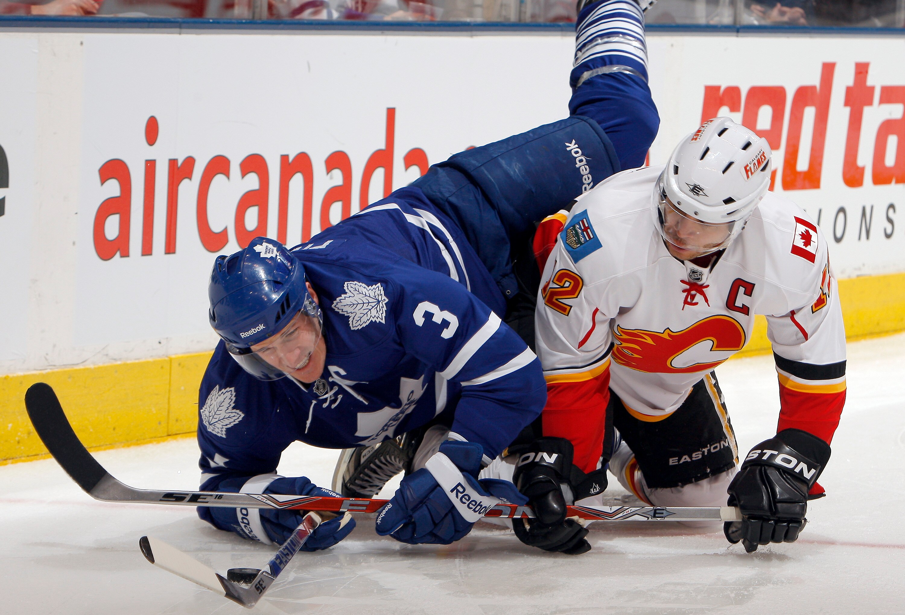 TORONTO, CANADA - JANUARY 15:  Dion Phaneuf #3 of the Toronto Maple Leafs gets caught up with Jarome Iginla #12 of the Calgary Flames during game action at the Air Canada Centre January 15, 2011 in Toronto, Ontario, Canada. (Photo by Abelimages/Getty Imag