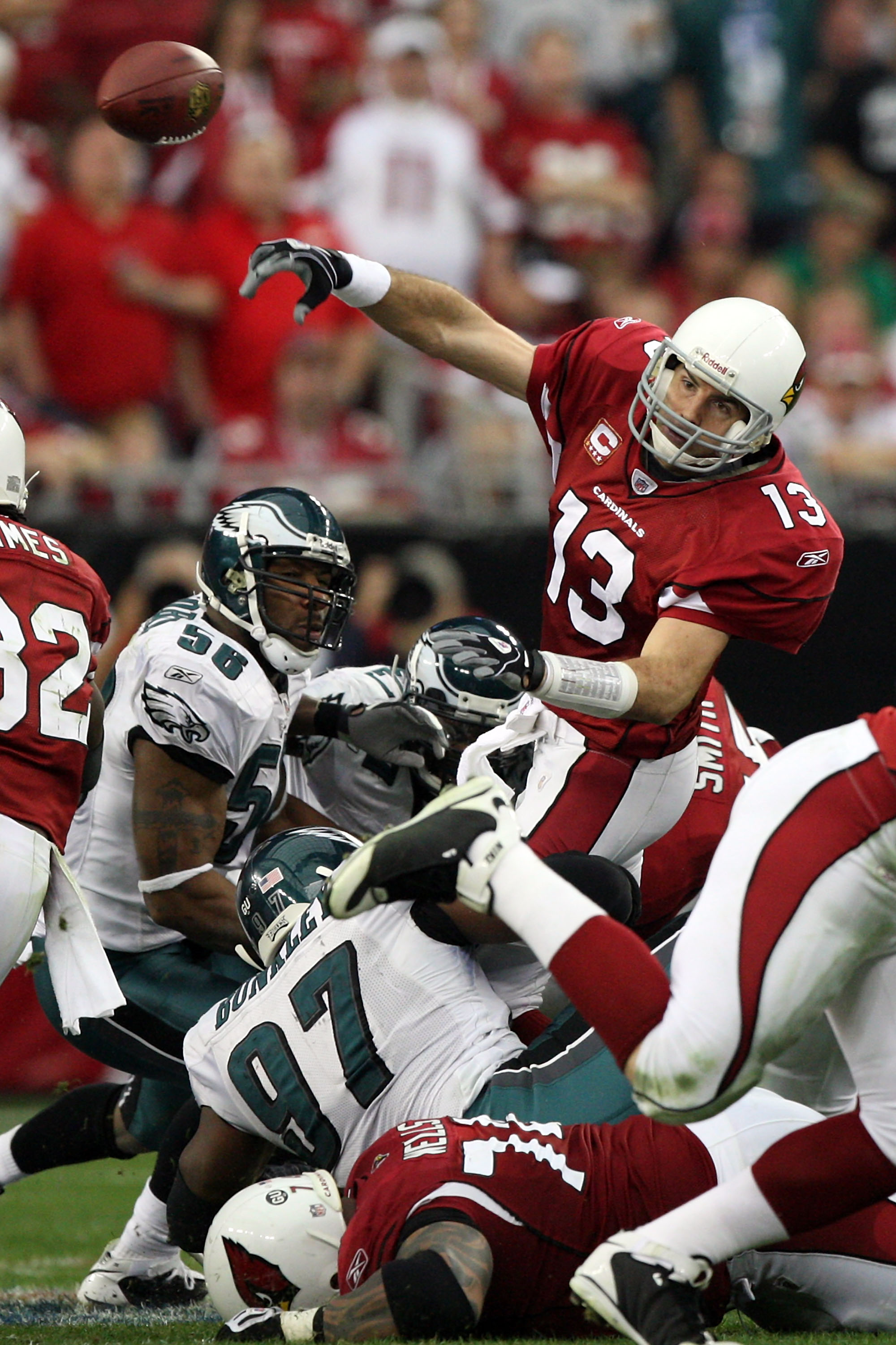 GLENDALE, AZ - JANUARY 18:  Quarterback Kurt Warner #13 of the Arizona Cardinals throws the ball as he is hit by Philadelphia Eagles defenders during the NFC championship game on January 18, 2009 at University of Phoenix Stadium in Glendale, Arizona.  (Ph