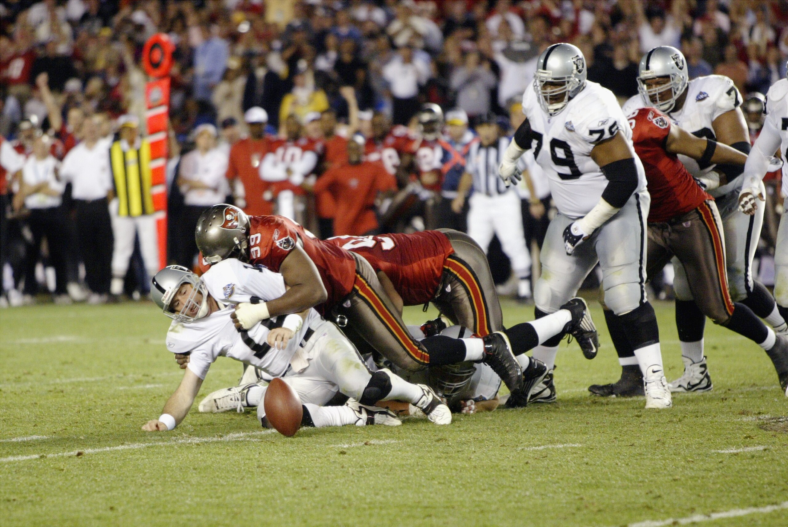 SAN DIEGO - JANUARY 26:  Quarterback Rich Gannon #12 of the Oakland Raiders fumbles the ball after being hit and sacked for a nine yard loss by Warren Sapp #99 of the Tampa Bay Buccaneers on the Oakland 29 yard line at 2:00 of the fourth quarter of Super