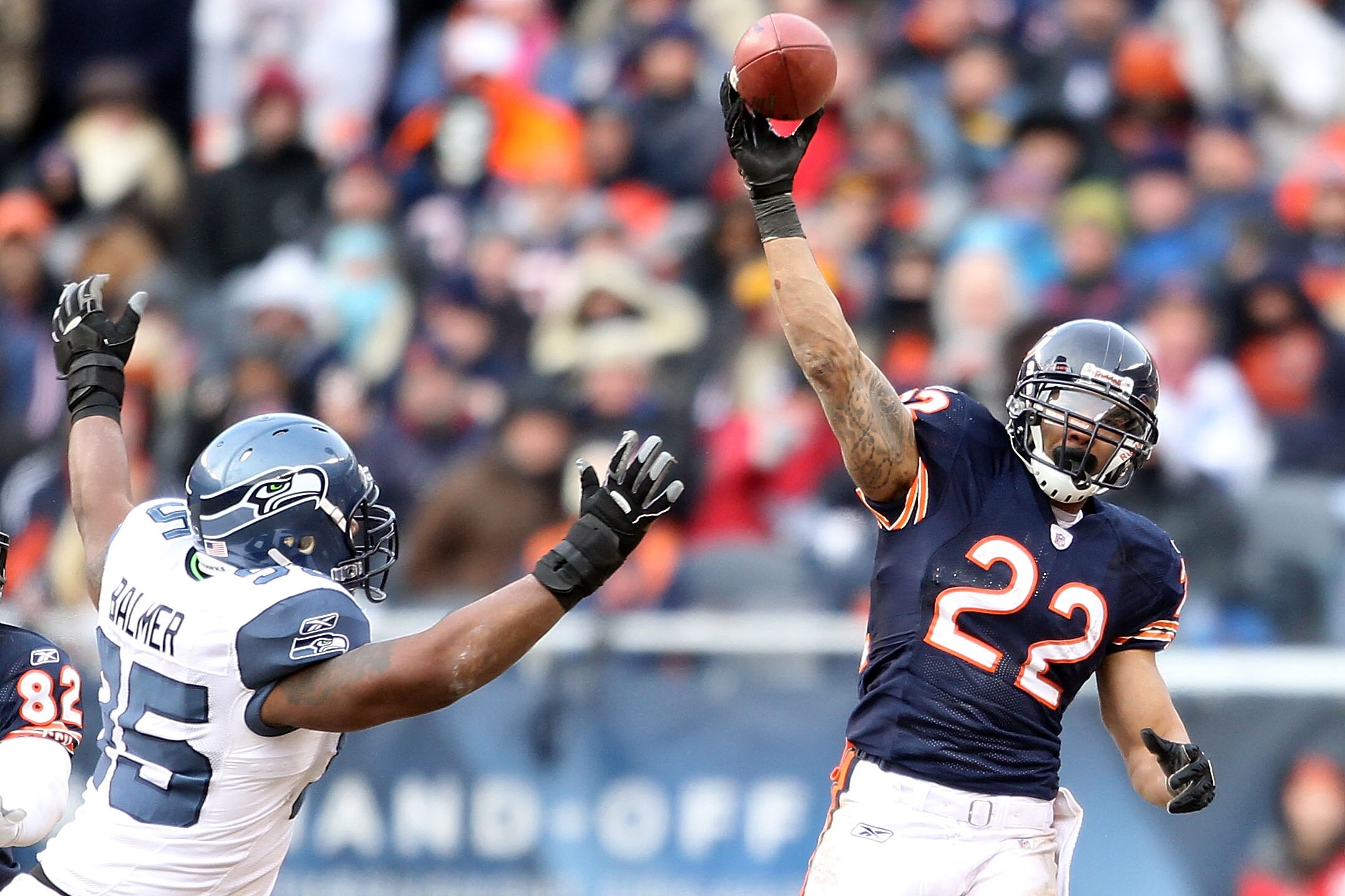 CHICAGO, IL - JANUARY 16:  Running back Matt Forte #22 of the Chicago Bears throws a pass over the arm of Kentwan Balmer #95 of the Seattle Seahawks as the pass is intercepted by Aaron Curry #59 in the second half of the 2011 NFC divisional playoff game a