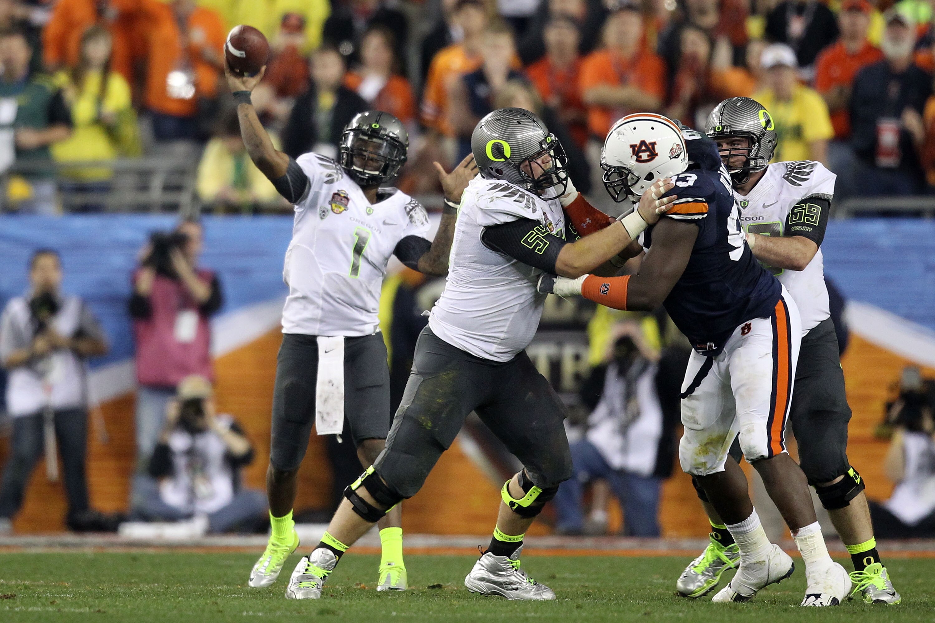 GLENDALE, AZ - JANUARY 10:  Jordan Holmes #54 of the Oregon Ducks blocks Mike Blanc #93 of the Auburn Tigers as Darron Thomas #1 of the Oregon Ducks looks to pass during the Tostitos BCS National Championship Game at University of Phoenix Stadium on Janua