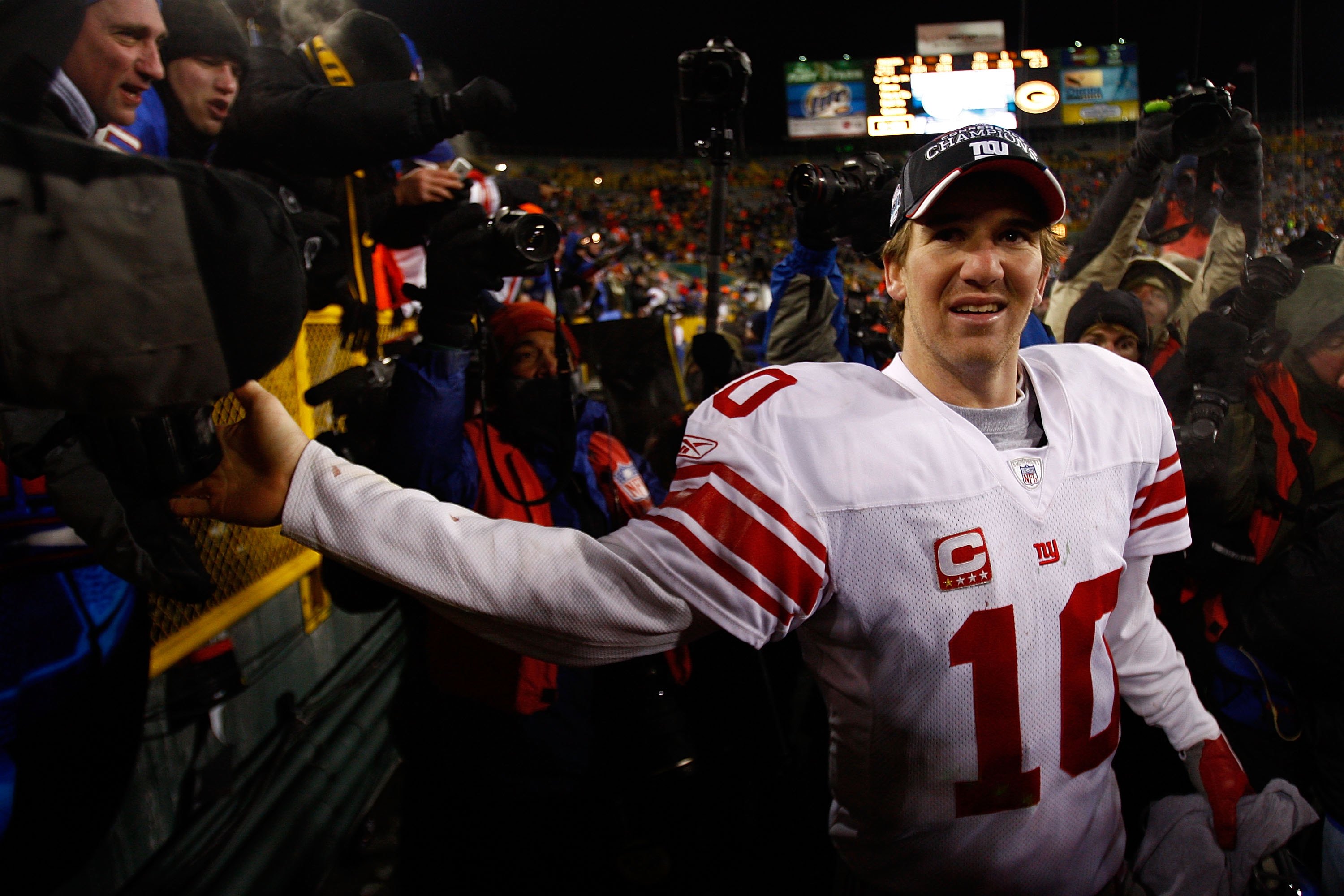 GREEN BAY, WI - JANUARY 20:  Quarterback Eli Manning #10 of the New York Giants celebrates with fans after winning the NFC championship game against the Green Bay Packers on January 20, 2008 at Lambeau Field in Green Bay, Wisconsin.   The Giants defeated