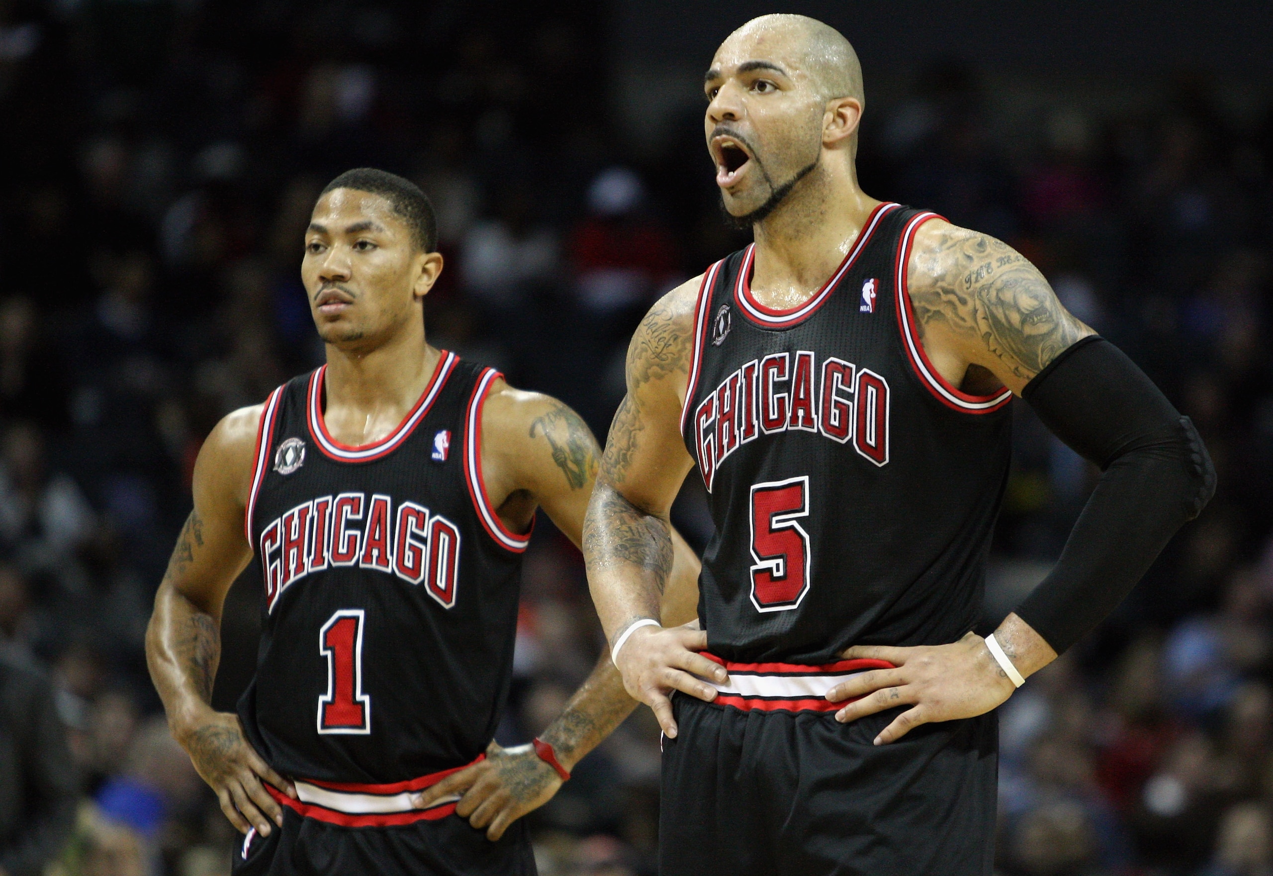 CHARLOTTE, NC - JANUARY 12:  Carlos Boozer #5 of the Chicago Bulls yells at a player as his teammate Derrick Rose #1 watches on against the Charlotte Bobcats during their game at Time Warner Cable Arena on January 12, 2011 in Charlotte, North Carolina. NO
