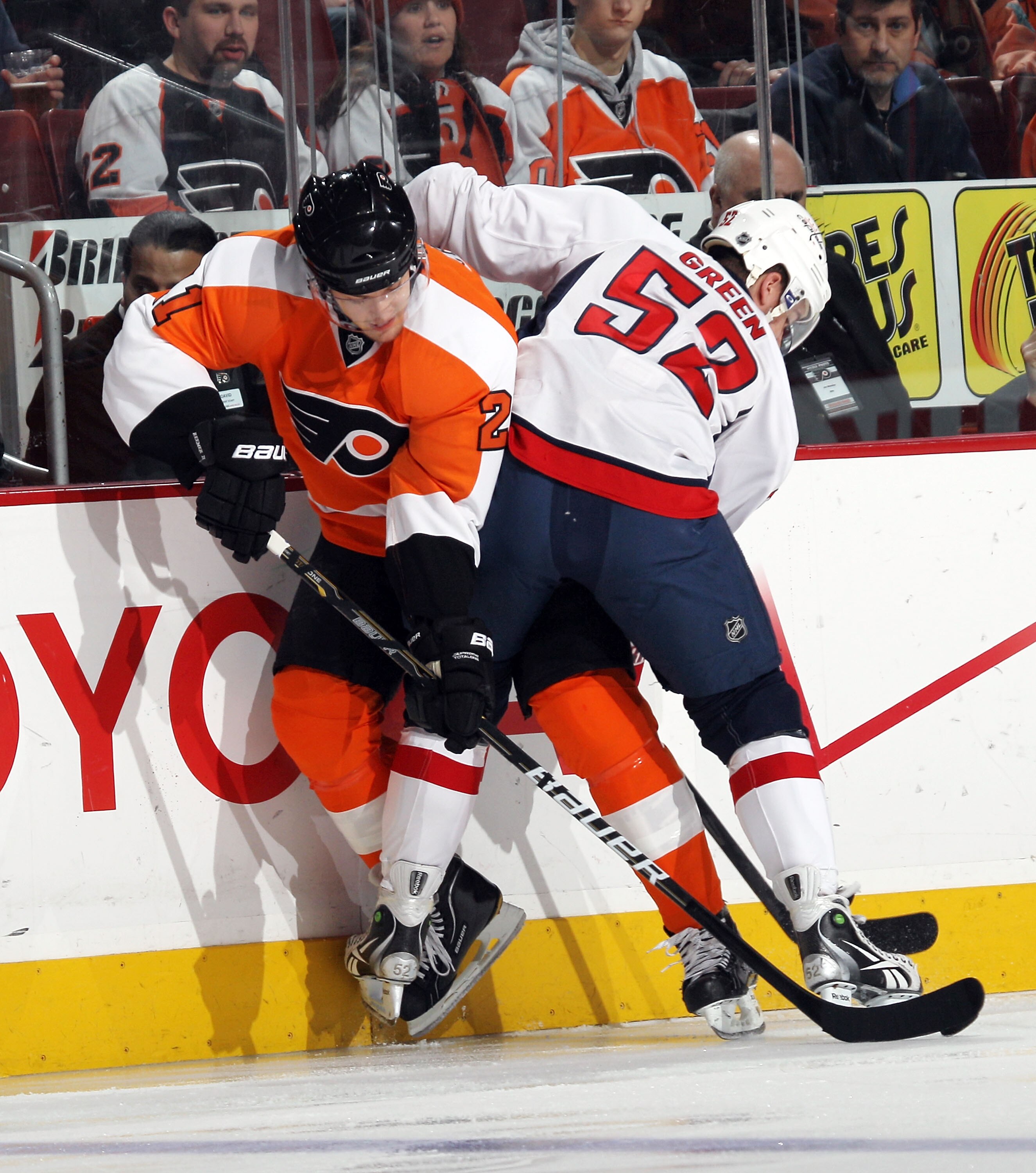 PHILADELPHIA, PA - JANUARY 18: Mike Green #52 of the Washington Capitals hits James van Riemsdyk #21 of the Philadelphia Flyers into the boards at the Wells Fargo Center on January 18, 2011 in Philadelphia, Pennsylvania. (Photo by Bruce Bennett/Getty Imag