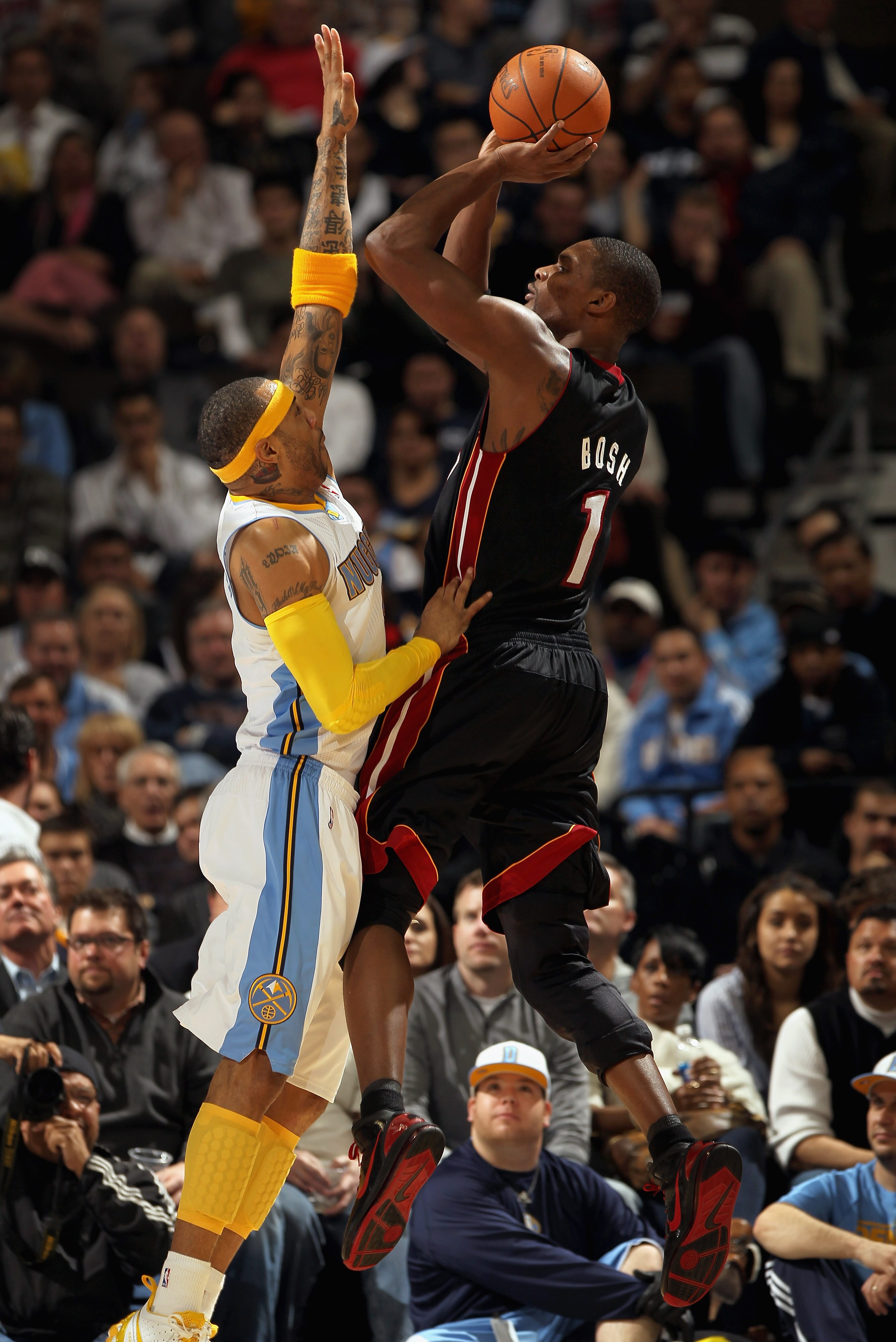 DENVER, CO - JANUARY 13:  (L-R) Chris Bosh #1 of the Miami Heat takes a shot over Kenyon Martin #4 of the Denver Nuggets at the Pepsi Center on January 13, 2011 in Denver, Colorado. The Nuggets defeated the Heat 130-102. NOTE TO USER: User expressly ackno
