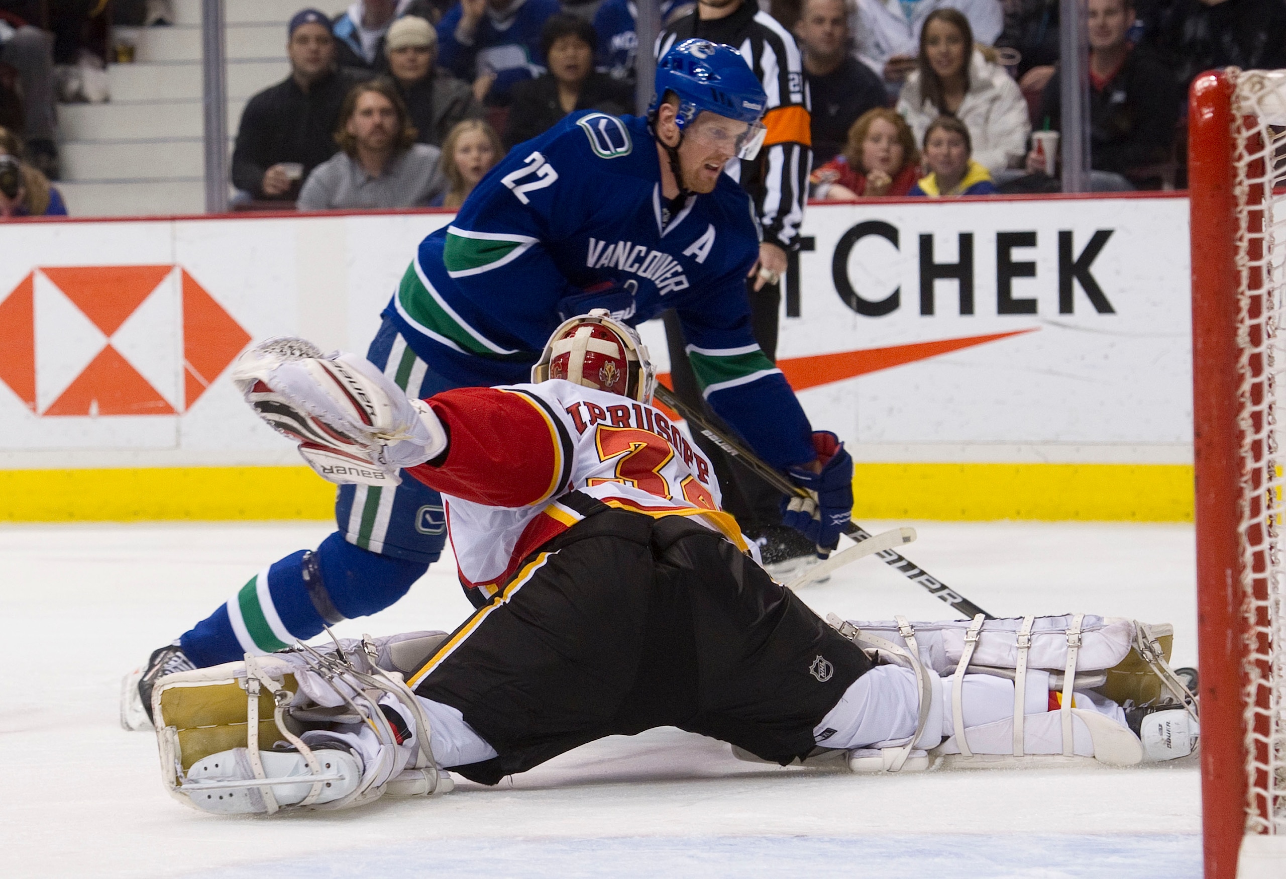 VANCOUVER, CANADA - JANUARY 5: Goalie Miikka Kiprusoff #34 of the Calgary Flames stretches out to stop Daniel Sedin #22 of the Vancouver Canucks during the second period in NHL action on January 05, 2011 at Rogers Arena in Vancouver, BC, Canada.  (Photo b