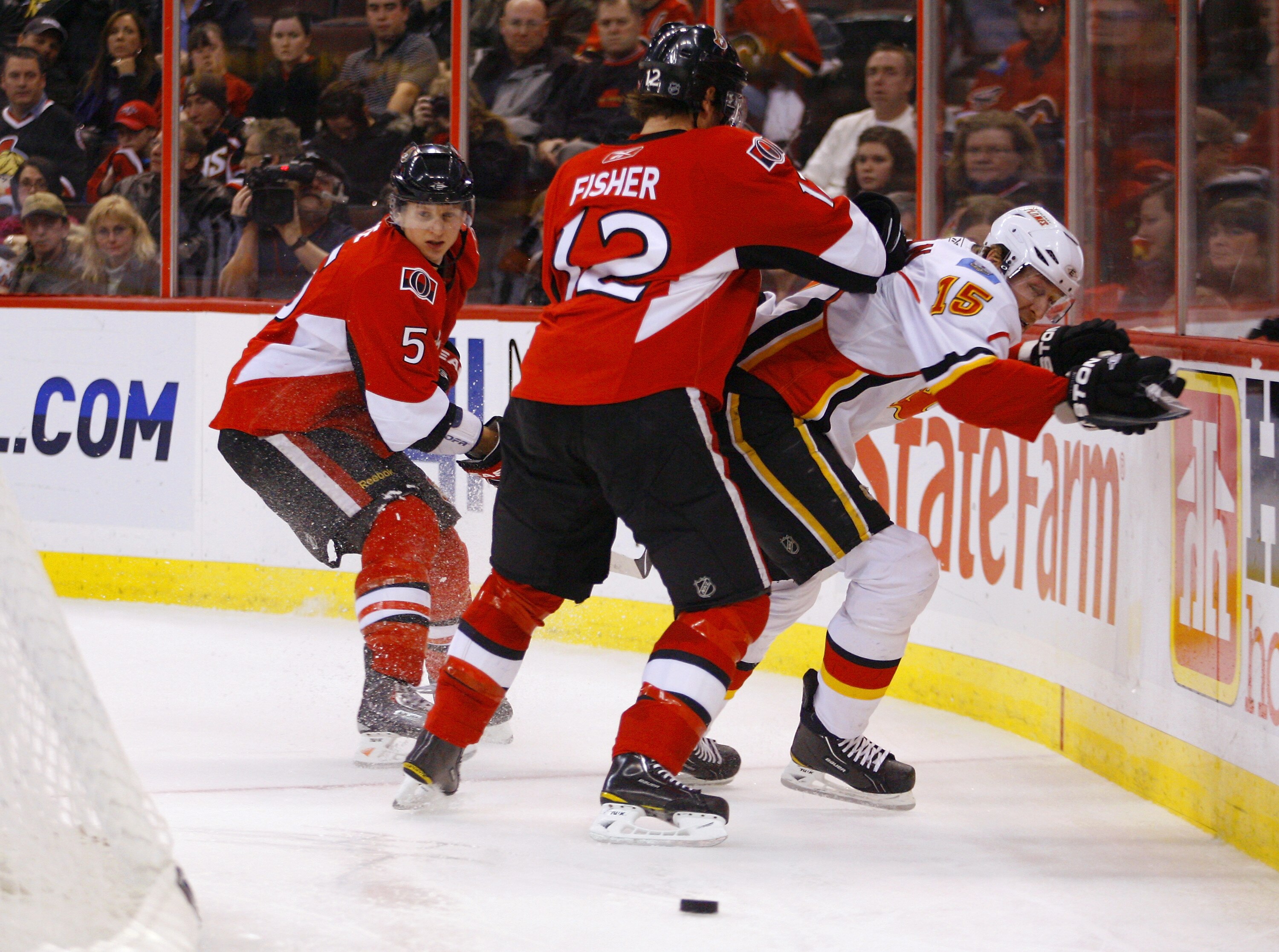 OTTAWA, ON - JANUARY 14: Mike Fisher #12 of the Ottawa Senators knocks Tim Jackman #15 of the Calgary Flames off the puck in behind the net in a game at Scotiabank Place on January 14, 2011 in Ottawa, Canada. The Flames won 3-2. (Photo by Phillip MacCall OTTAWA, ON - JANUARY 14: Mike Fisher #12 of the Ottawa Senators knocks Tim Jackman #15 of the Calgary Flames off the puck in behind the net in a game at Scotiabank Place on January 14, 2011 in Ottawa, Canada. The Flames won 3-2. (Photo by Phillip MacCall