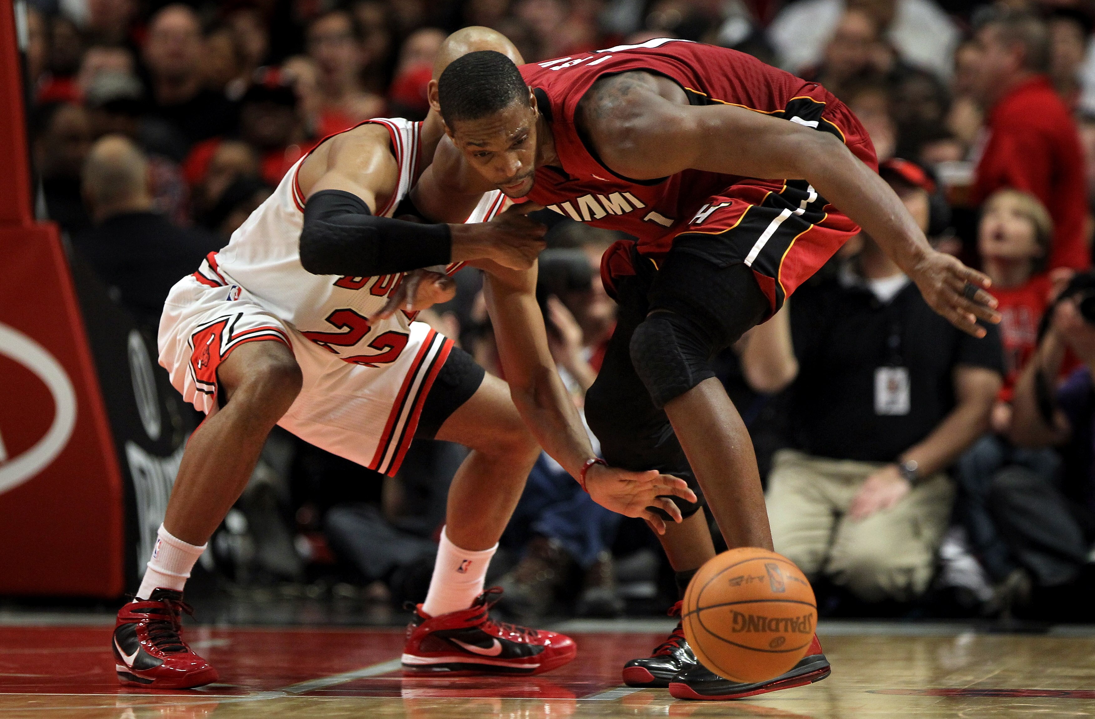 CHICAGO, IL - JANUARY 15:  Chris Bosh #1 of the Miami Heat battles for a loose ball with Taj Gibson #22 of the Chicago Bulls at the United Center on January 15, 2011 in Chicago, Illinois. The Bulls defeated the Heat 99-96. NOTE TO USER: User expressly ack