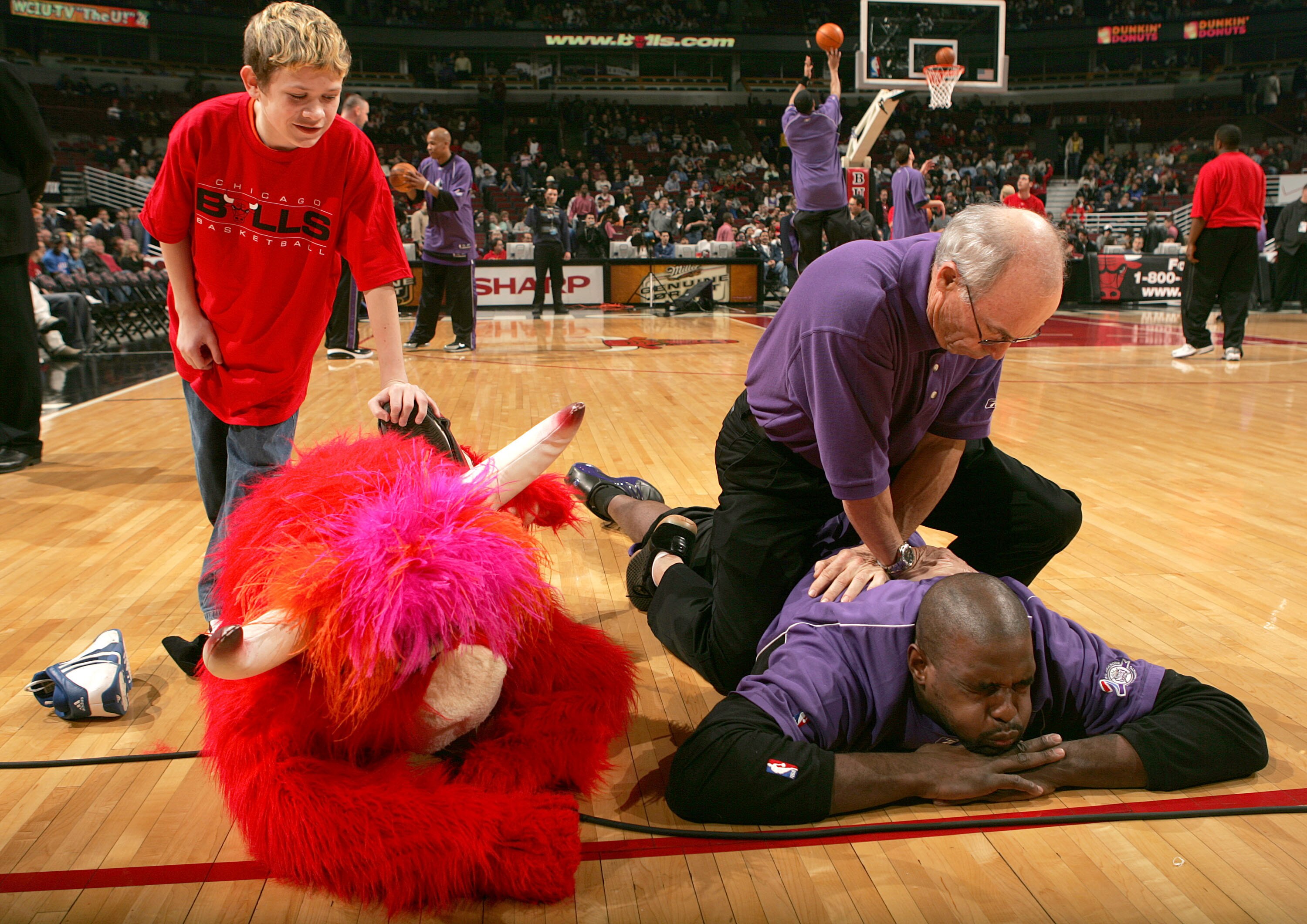 CHICAGO - FEBRUARY 15:  A Fan helps the Chicago Bulls Mascot, Benny, stretch next to Chris Webber #4 of the Sacramento Kings before a game on February 15, 2005 at the United Center in Chicago, Illinois. The Bulls defeated the kings 107-102.  NOTE TO USER:
