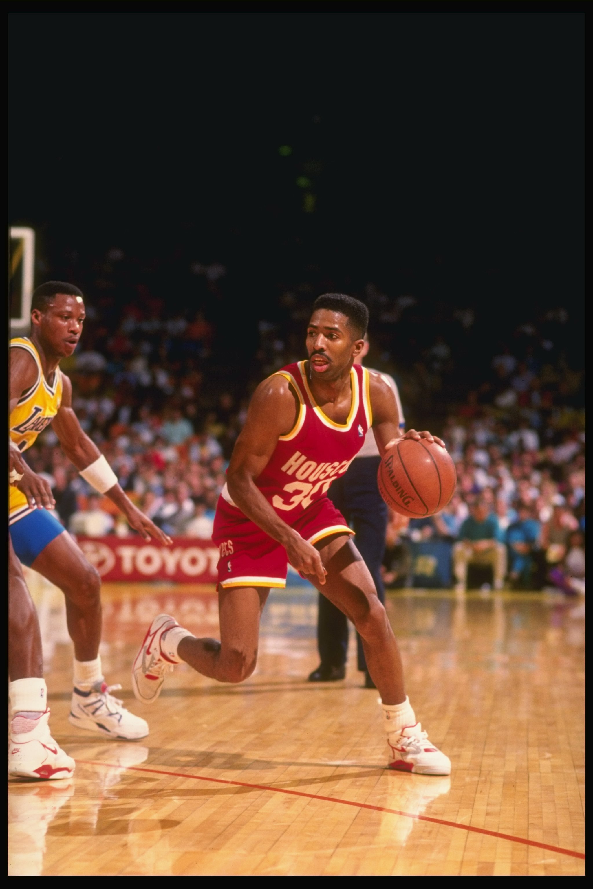 1990-1991:  Guard Kenny Smith of the Houston Rockets tries to keep the ball away from guard Byron Scott of the Los Angeles Lakers (left) during a game at the Great Western Forum in Inglewood, California. Mandatory Credit: Ken Levine  /Allsport