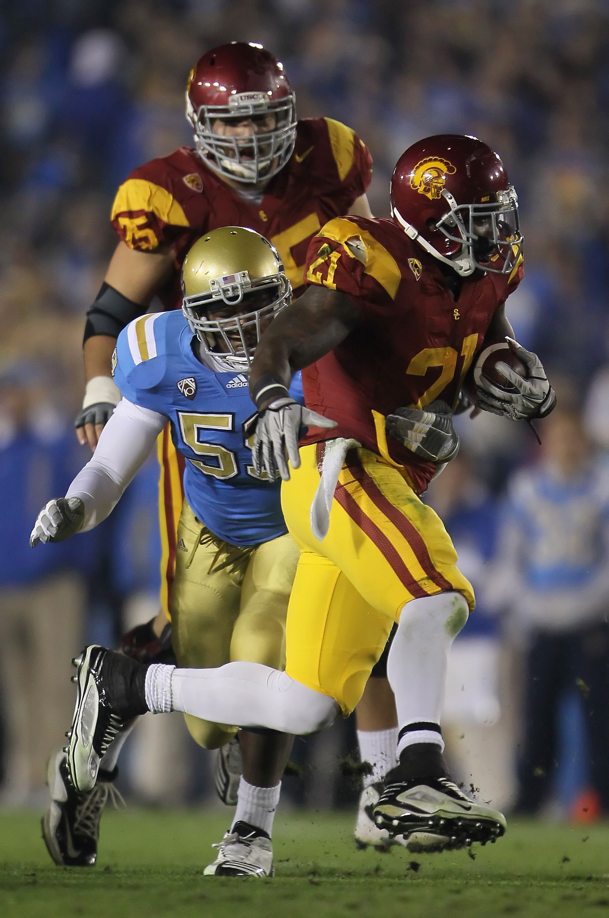 PASADENA, CA - DECEMBER 04:  Running back Allen Bradford #21 of the USC Trojans is tackled by Keenan Graham #59 of the UCLA Bruins during the first half at the Rose Bowl on December 4, 2010 in Pasadena, California. USC defeated UCLA 28-14.  (Photo by Jeff