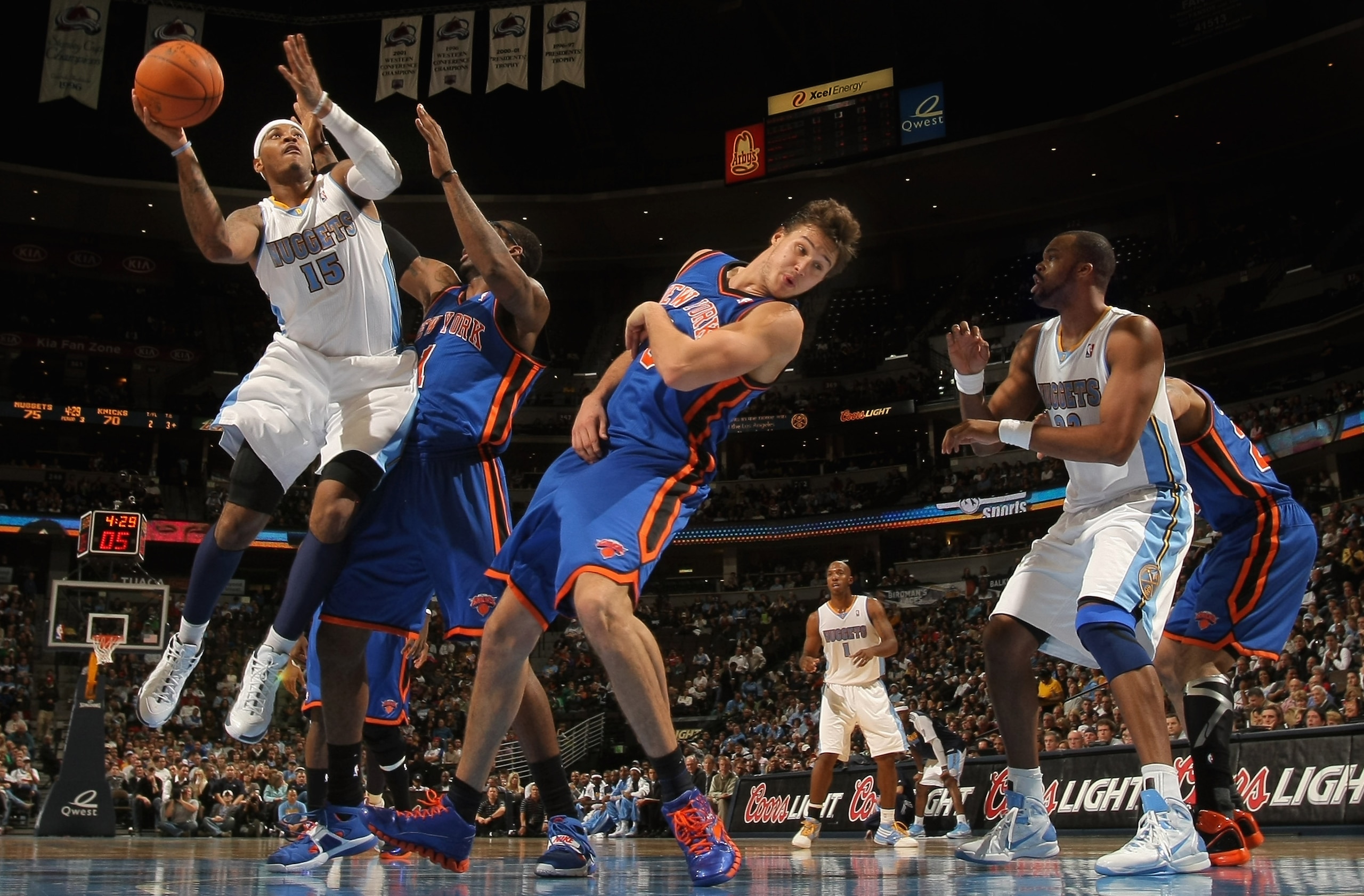 DENVER - NOVEMBER 16:  Carmelo Anthony #15 of the Denver Nuggets puts up a shot over Amar'e Stoudemire #1 and Danilo Gallinari #8 of the New York Knicks at the Pepsi Center on November 16, 2010 in Denver, Colorado. The Nuggets defeated the Knicks 120-118.