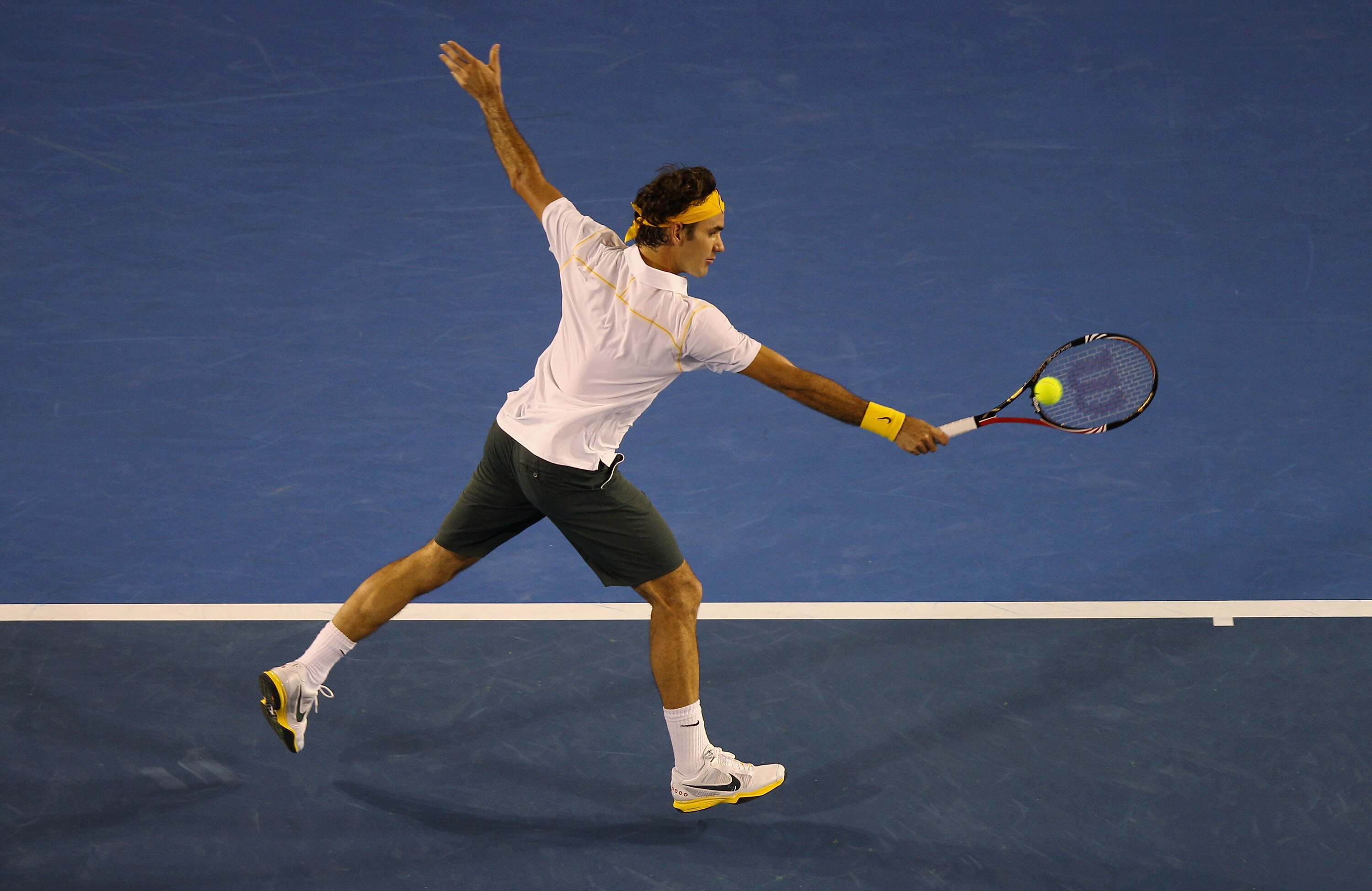 MELBOURNE, AUSTRALIA - JANUARY 19:  Roger Federer of Switzerland plays a backhand in his second round match against Gilles Simon of France during day three of the 2011 Australian Open at Melbourne Park on January 19, 2011 in Melbourne, Australia.  (Photo