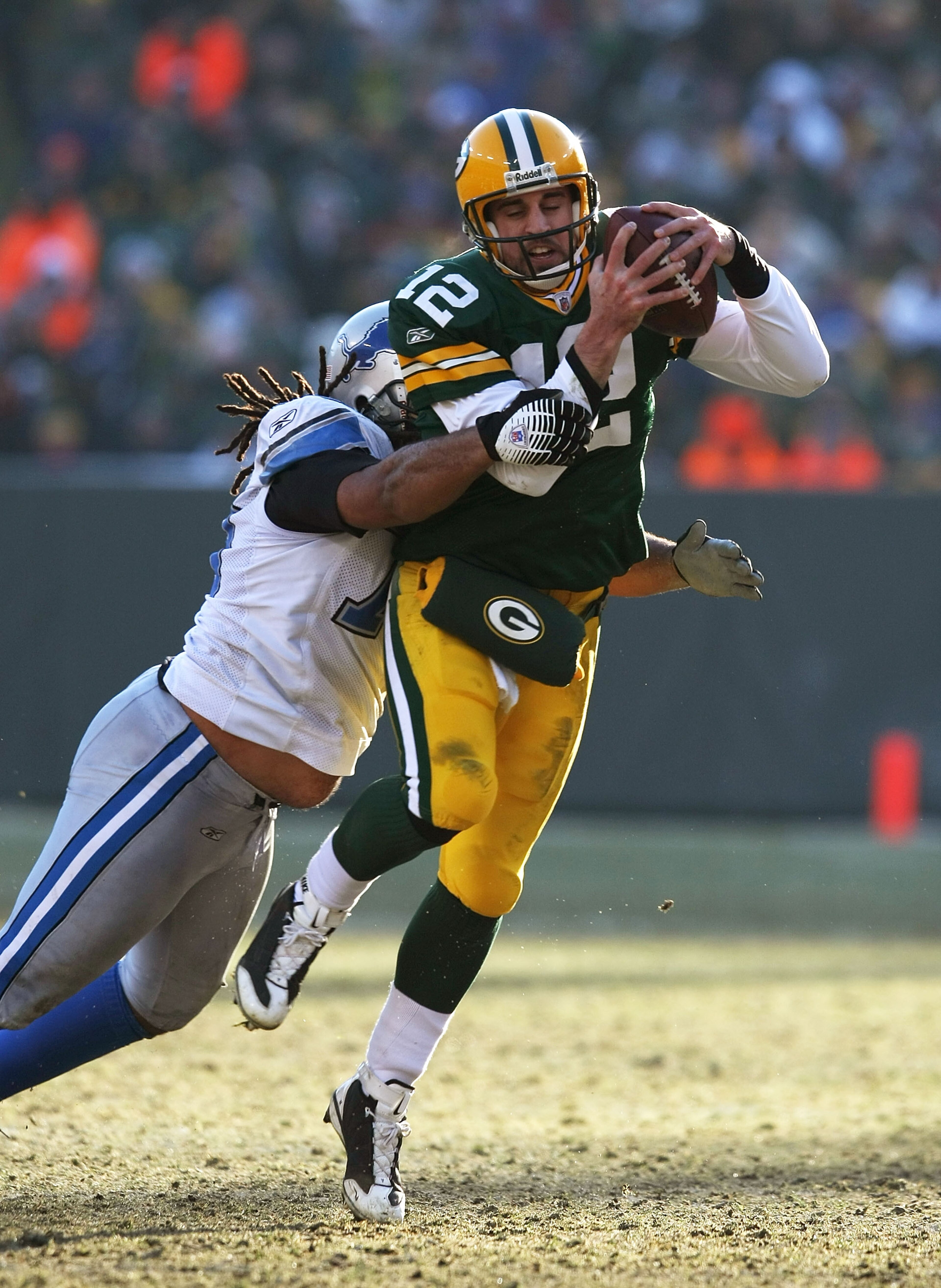 GREEN BAY, WI - DECEMBER 28: Aaron Rodgers #12 of the Green Bay Packers is brought down by Ikaika Alamam-Francis #97 of the Detroit Lions on December 28, 2008 at Lambeau Field in Green Bay, Wisconsin. The Packers defeated the Lions 31-21. (Photo by Jonath