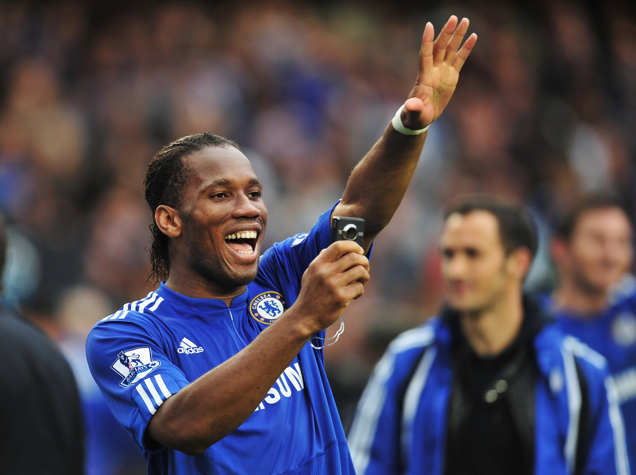 LONDON, ENGLAND - MAY 09:  Didier Drogba of Chelsea takes a photograph on his mobile phone as he celebrates winning the title after the Barclays Premier League match between Chelsea and Wigan Athletic at Stamford Bridge on May 9, 2010 in London, England.