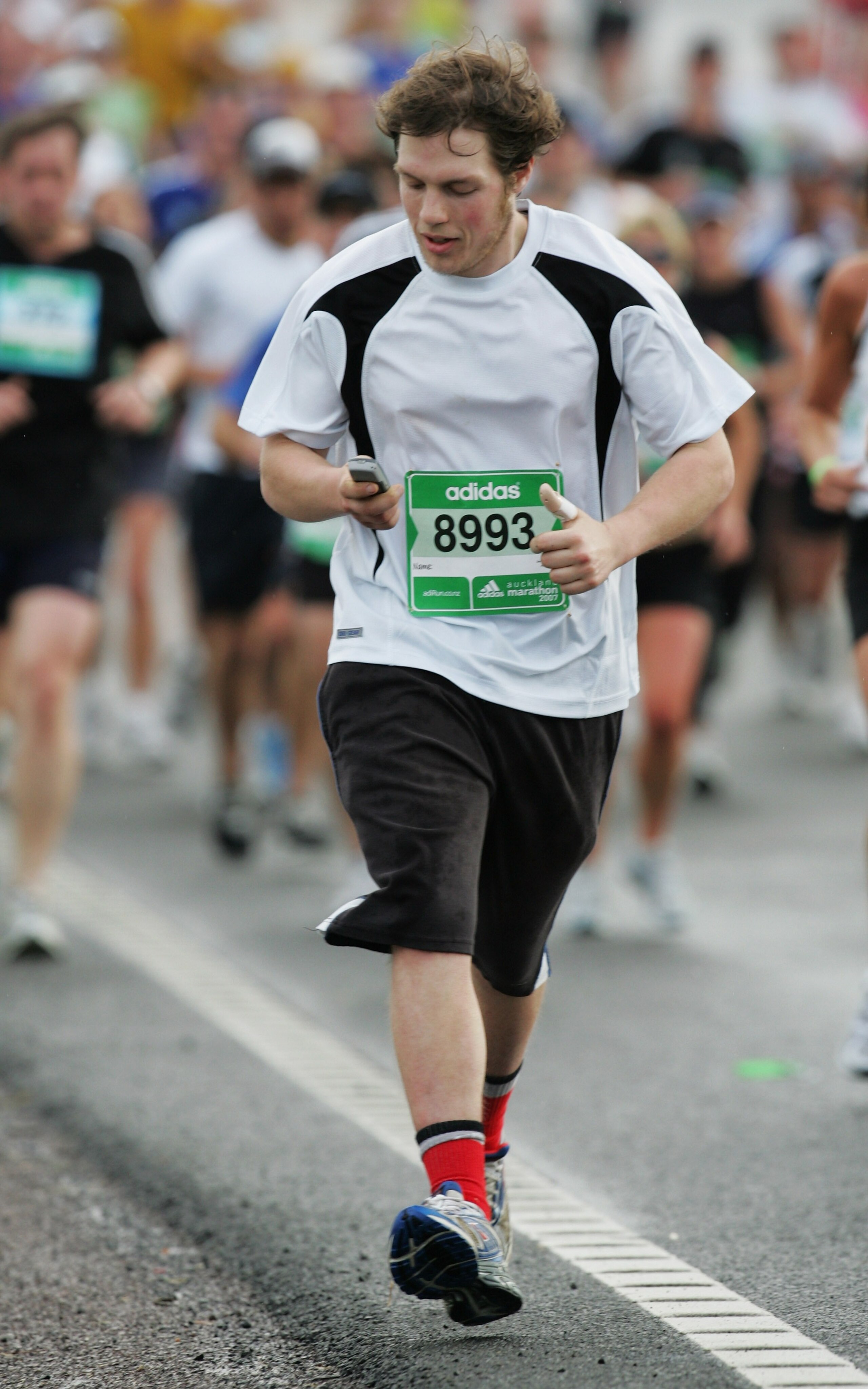 AUCKLAND, NEW ZEALAND - OCTOBER 28: A runner sends a text from his mobile phone as he crosses the Harbour Bridge during the Auckland Marathon October 28, 2007 in Auckland, New Zealand. (Photo by Sandra Mu/Getty Images)