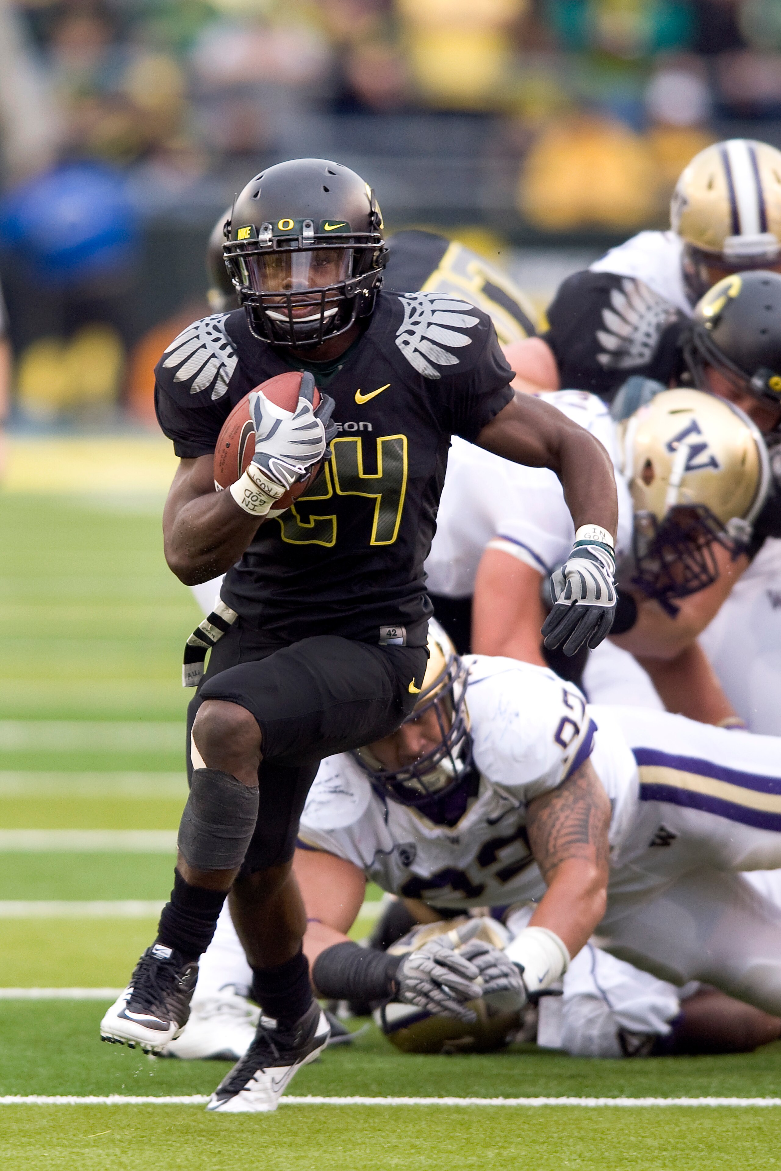 EUGENE, OR - NOVEMBER 6: Running back Kenjon Barner #24 of the Oregon Ducks leaves a pile of defenders as he runs with the ball in the fourth quarter of the game against the Washington Huskies at Autzen Stadium on November 6, 2010 in Eugene, Oregon. The D