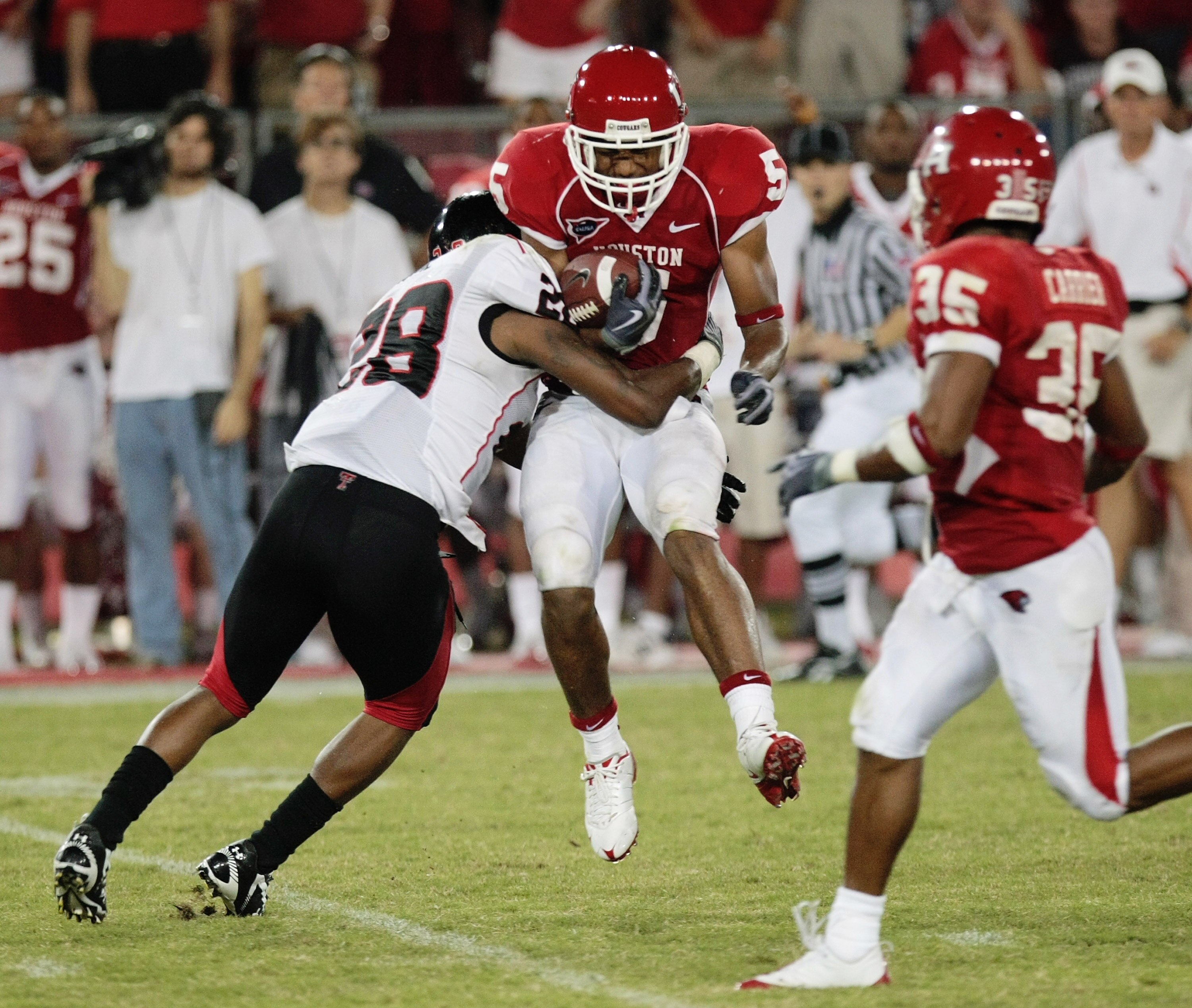 HOUSTON - SEPTEMBER 26: Running back Charles Sims #5 of the Houston Cougars is leveled by defensive back LaRon Moore #28 of the Texas Tech Red Raiders at Robertson Stadium on September 26, 2009 in Houston, Texas.  (Photo by Thomas B. Shea/Getty Images)