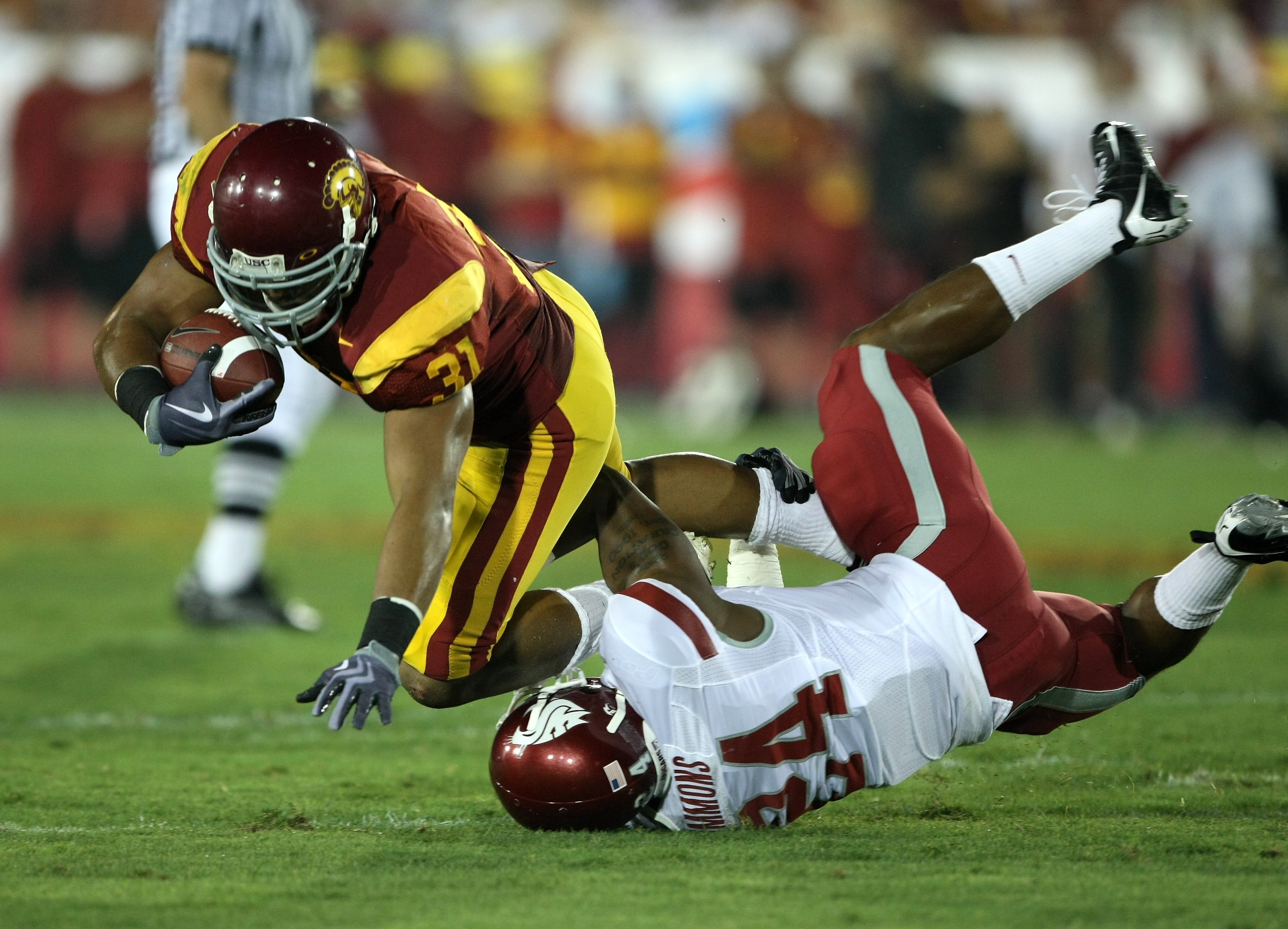LOS ANGELES, CA - SEPTEMBER 26:  Fullback Stanley Havili #31 of the USC Trojans is tackled by defensive back Daniel Simmons #24 of the Washington State Cougars on September 23, 2009 at the Los Angeles Coliseum in Los Angeles, California.  USC won 27-6.  (