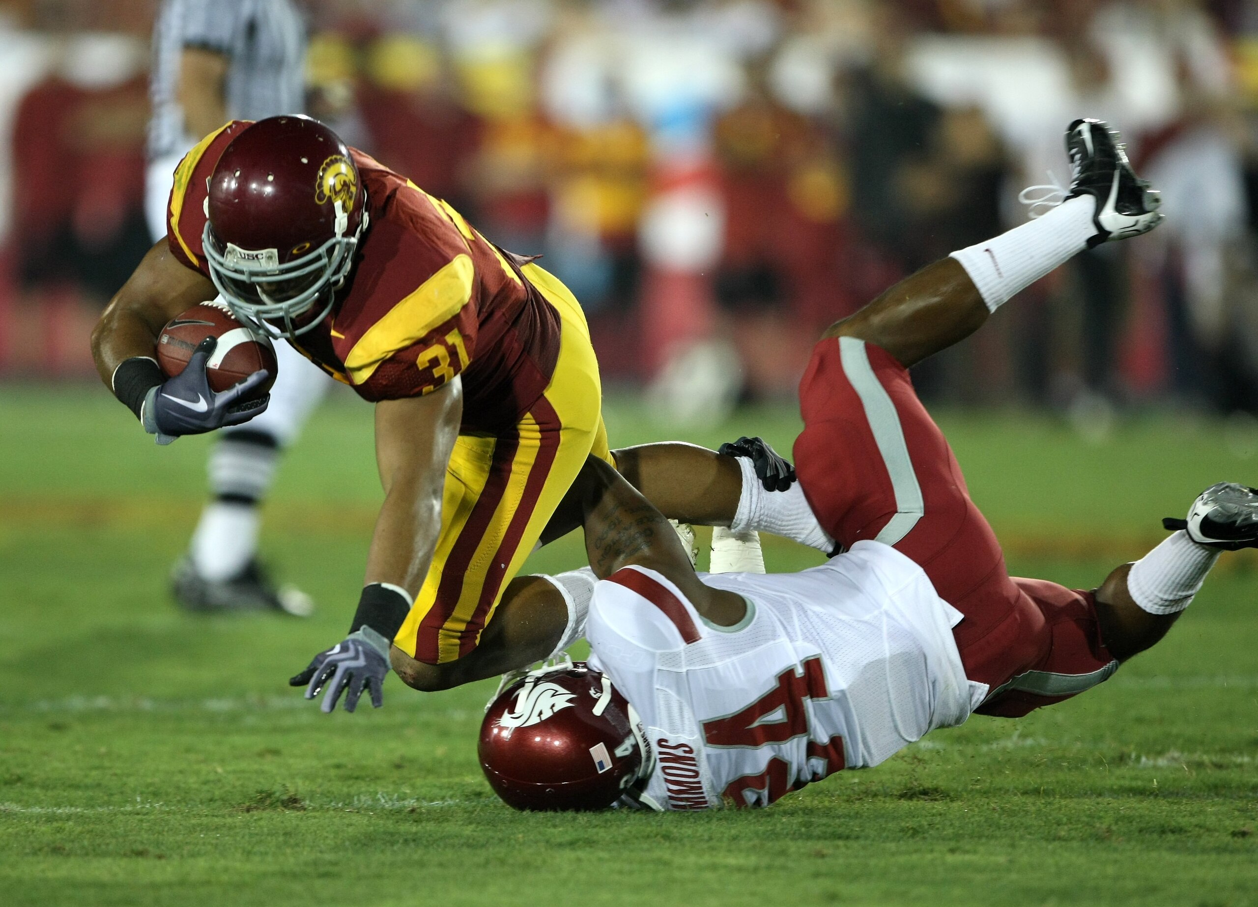 LOS ANGELES, CA - SEPTEMBER 26:  Fullback Stanley Havili #31 of the USC Trojans is tackled by defensive back Daniel Simmons #24 of the Washington State Cougars on September 23, 2009 at the Los Angeles Coliseum in Los Angeles, California.  USC won 27-6.  (